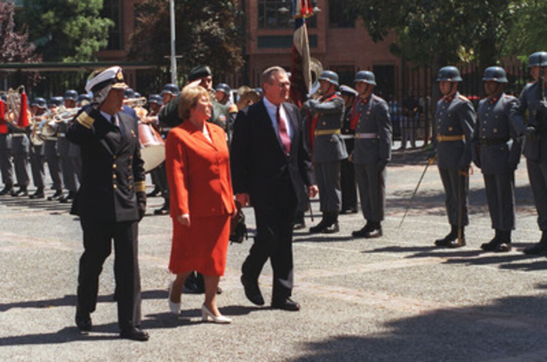 Chilean Minister of Defense Michelle Bachelet (center) escorts Secretary of Defense Donald H. Rumsfeld (right) as he reviews the troops during an armed forces full honors welcoming ceremony at the Chilean Ministry of Defense in Santiago, Chile, on Nov. 18, 2002. Rumsfeld is in Santiago to attend the Defense Ministerial of the Americas. 