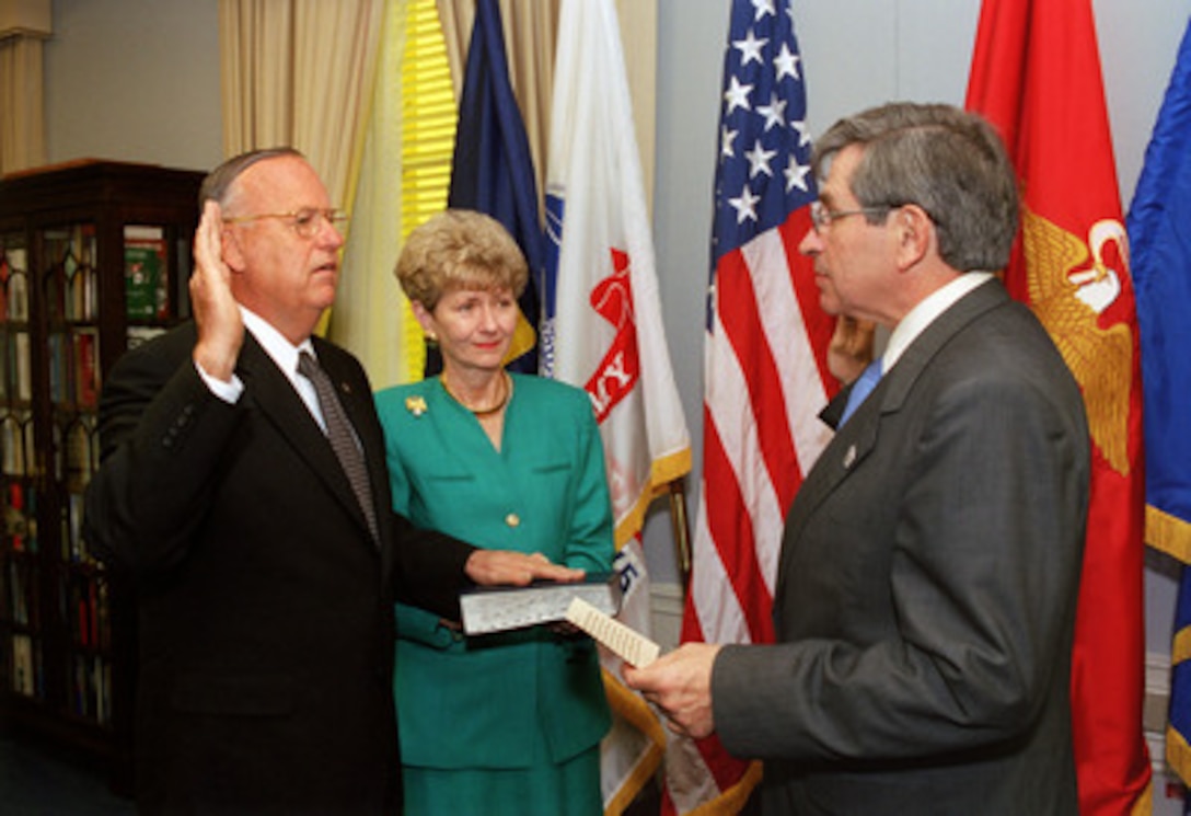 Thomas F. Hall (left) is sworn in as the nation's fourth assistant secretary of defense for reserve affairs in the Pentagon on Oct. 9, 2002. Administering the oath of office is Deputy Secretary of Defense Paul Wolfowitz (right), while Hall's wife Barbara holds the Bible. 