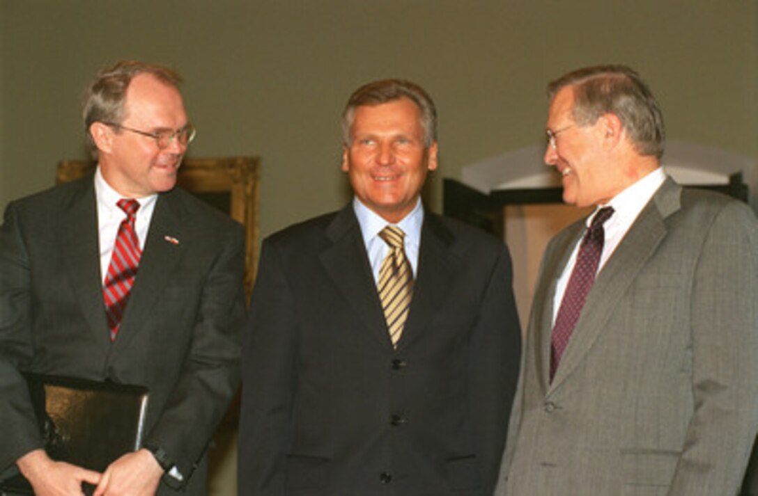 U.S. Ambassador to Poland Christopher Hill (left), Polish President Aleksander Kwasniewski (center), and Secretary of Defense Donald H. Rumsfeld (right) pose for photographers at the Presidential Palace in Warsaw, Poland, on Sept. 23, 2002. Rumsfeld met with senior Polish officials before the annual informal meeting of NATO defense ministers held this year in Warsaw. 