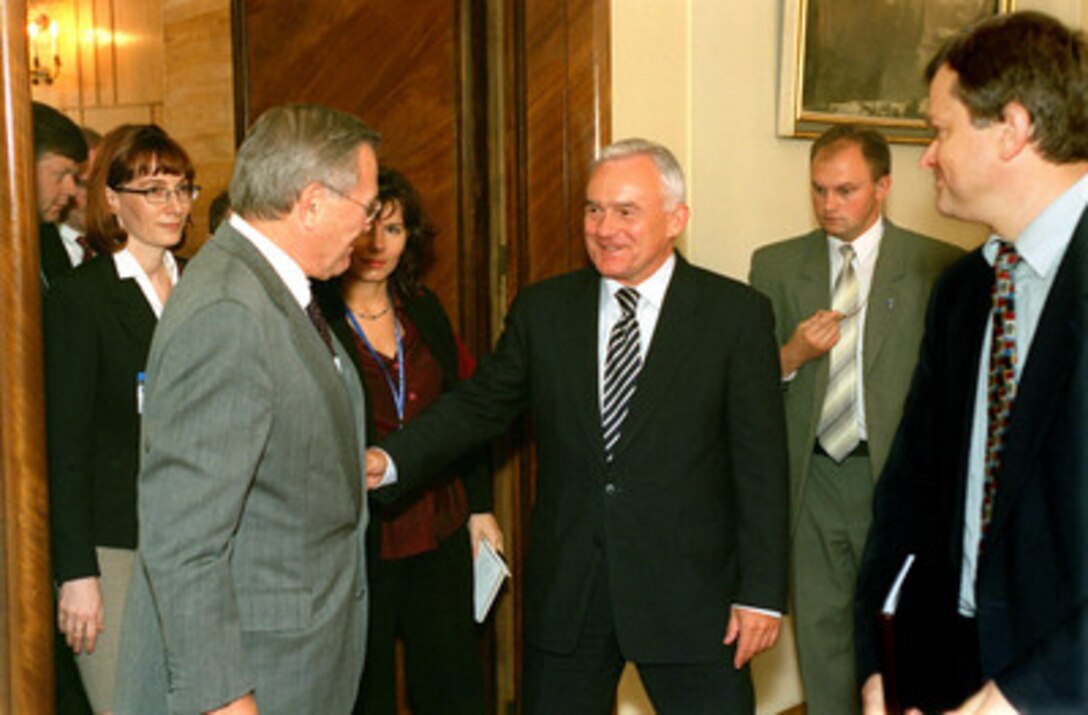 Polish Prime Minister Leszek Miller (center) escorts Secretary of Defense Donald H. Rumsfeld (left) from the conference room at the conclusion of their talks at the Chancellery in Warsaw, Poland, on Sept. 23, 2002. Rumsfeld is meeting with senior Polish officials before the annual informal meeting of NATO defense ministers held this year in Warsaw. 