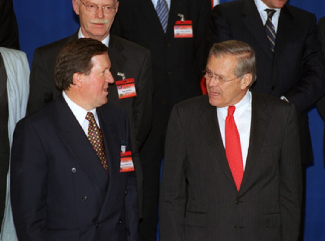 Secretary of Defense Donald H. Rumsfeld (right) talks with NATO Secretary General Lord George Robertson (left) while waiting for the other NATO defense ministers to assemble for a group photo at the annual informal meeting of NATO Defense Ministers, in Warsaw, Poland, on Sept. 24, 2002. Each Autumn the defense ministers gather at a select location within the borders of one of the member-nations, instead of their usual venue at NATO Headquarters in Brussels, Belgium, for the informal non-binding meetings. This year Poland became the first nation of NATO's former adversary--the Warsaw Pact--to host such an event. 