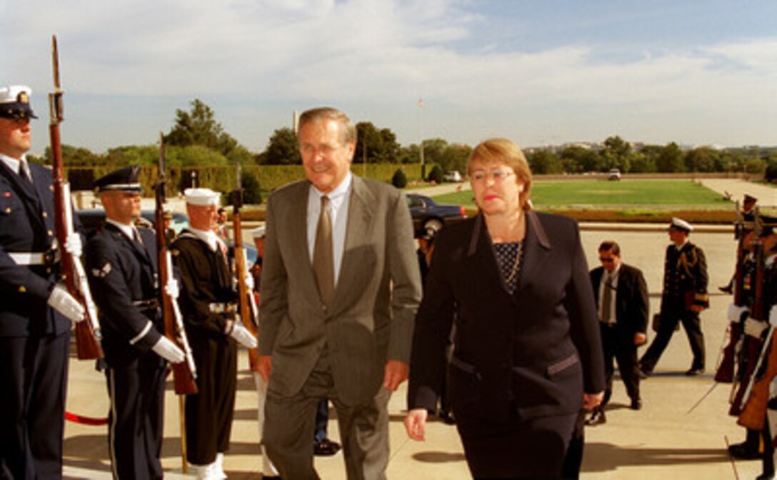 Secretary of Defense Donald H. Rumsfeld (left) escorts Minister of Defense Michelle Bachelet, of Chile, through an honor cordon and into the Pentagon on Oct. 8, 2002. The two defense leaders will meet to discuss a broad range of security issues, both regional and global in scope. 