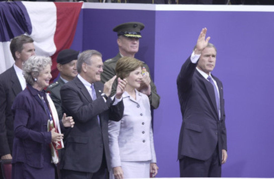 President George W. Bush and Mrs. Bush arrive at the Pentagon for the Sept. 11 Observance Ceremony escorted by Secretary of Defense Donald H. Rumsfeld and Mrs. Rumsfeld. More than 13,000 people attended the service to remember those who lost their lives one year ago when terrorists crashed a commercial airliner into the Department of Defense headquarters. 