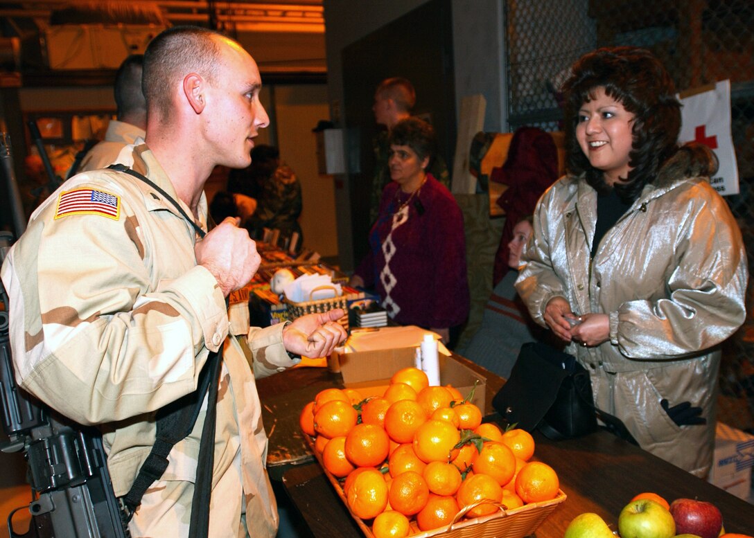 AVIANO AIR BASE, Italy -- Army Spc. Thomas Rinker, stationed out of Fort Lee, Va., asks Teresa Lyons, a volunteer here, if she could exchange dollars to euro as a souvenir.  Rinker and his company were awaiting transportation to a forward-deployed location.  (U.S. Air Force photo by Airman 1st Class Nichole Adamowicz)
