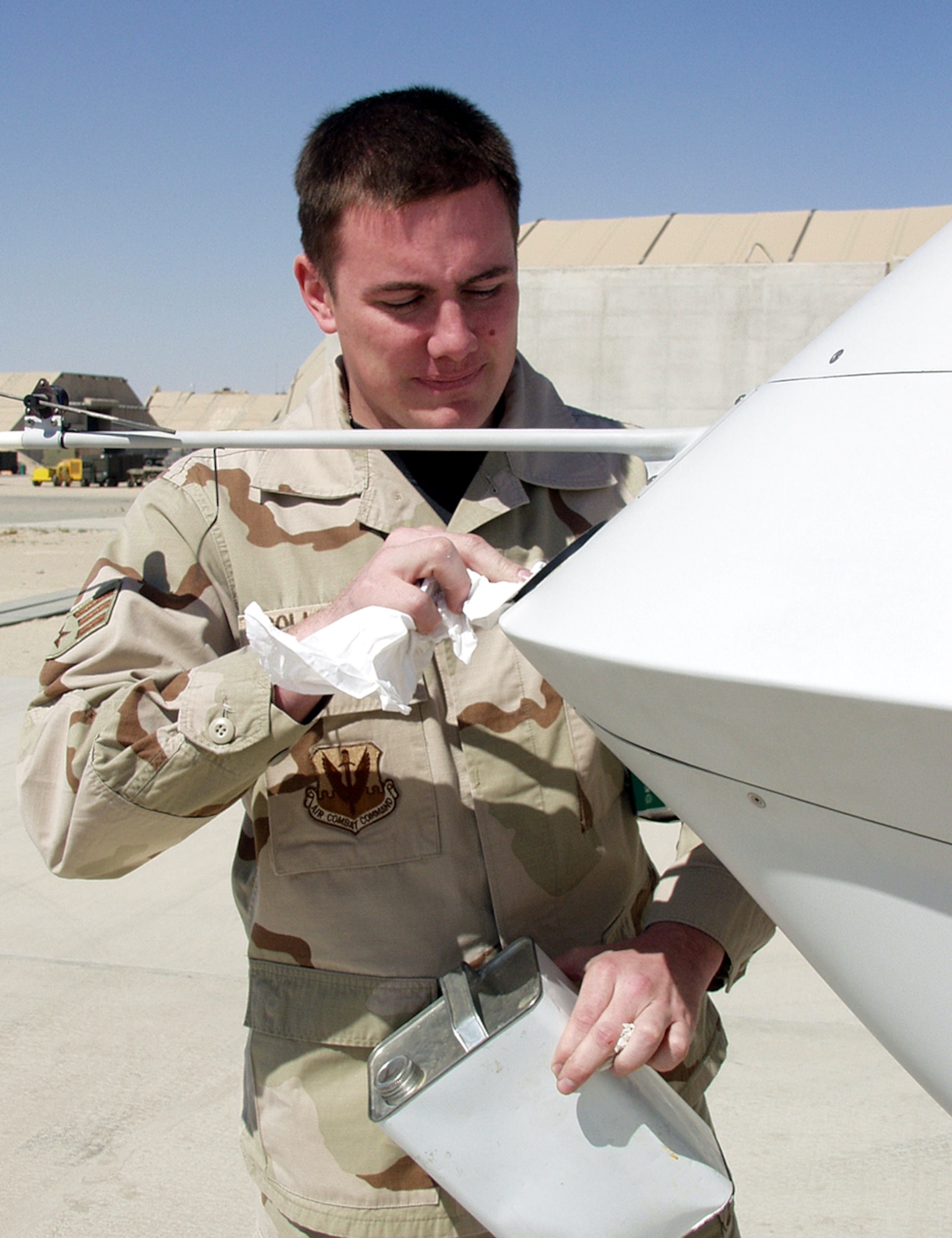 OPERATION IRAQI FREEDOM - Senior Airman Joseph Gollhofer, a 46th Expeditionary Reconnaissance Squadron crew chief, cleans the small lens pilots must use to fly the MQ-1 Predator. Pilots describe the view as "seeing through a straw" compared to typical aircraft. (U.S. Air Force photo by Staff Sgt. Karen J. Tomasik)