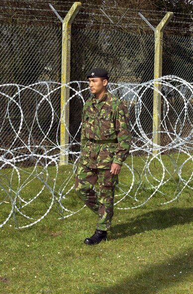ROYAL AIR FORCE FAIRFORD, England -- A rifleman from the 3rd Regiment of Gurkha Rifles, an elite unit within the British Army, patrols the perimeter here March 20. The legendary Nepali fighters of the 3rd RGR are hereat to safeguard the base, joining forces with Air Force security forces, Royal Air Force and Ministry of Defence Police and local constabularies.  (U.S. Air Force photo by Airman 1st Class Stacia Willis)