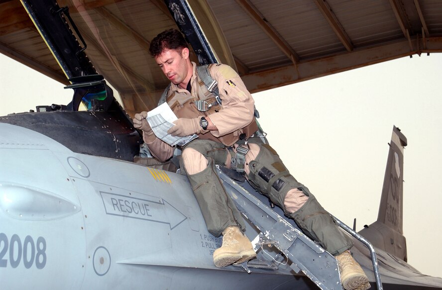 OPERATION IRAQI FREEDOM -- Capt. Jeremy "Edge" Quatacker, F-16 pilot with the 524th Expeditionary Fighter Squadron, checks his preflight forms prior to a mission in support of Operation Iraqi Freedom at a desert base in the Arabian Gulf Region. Operation Iraqi Freedom is the multinational coalition effort to liberate the Iraqi people, eliminate Iraq's weapons of mass destruction and end the regime of Saddam Hussein. (U.S. Air Force photo by Master Sgt. Stefan Alford)