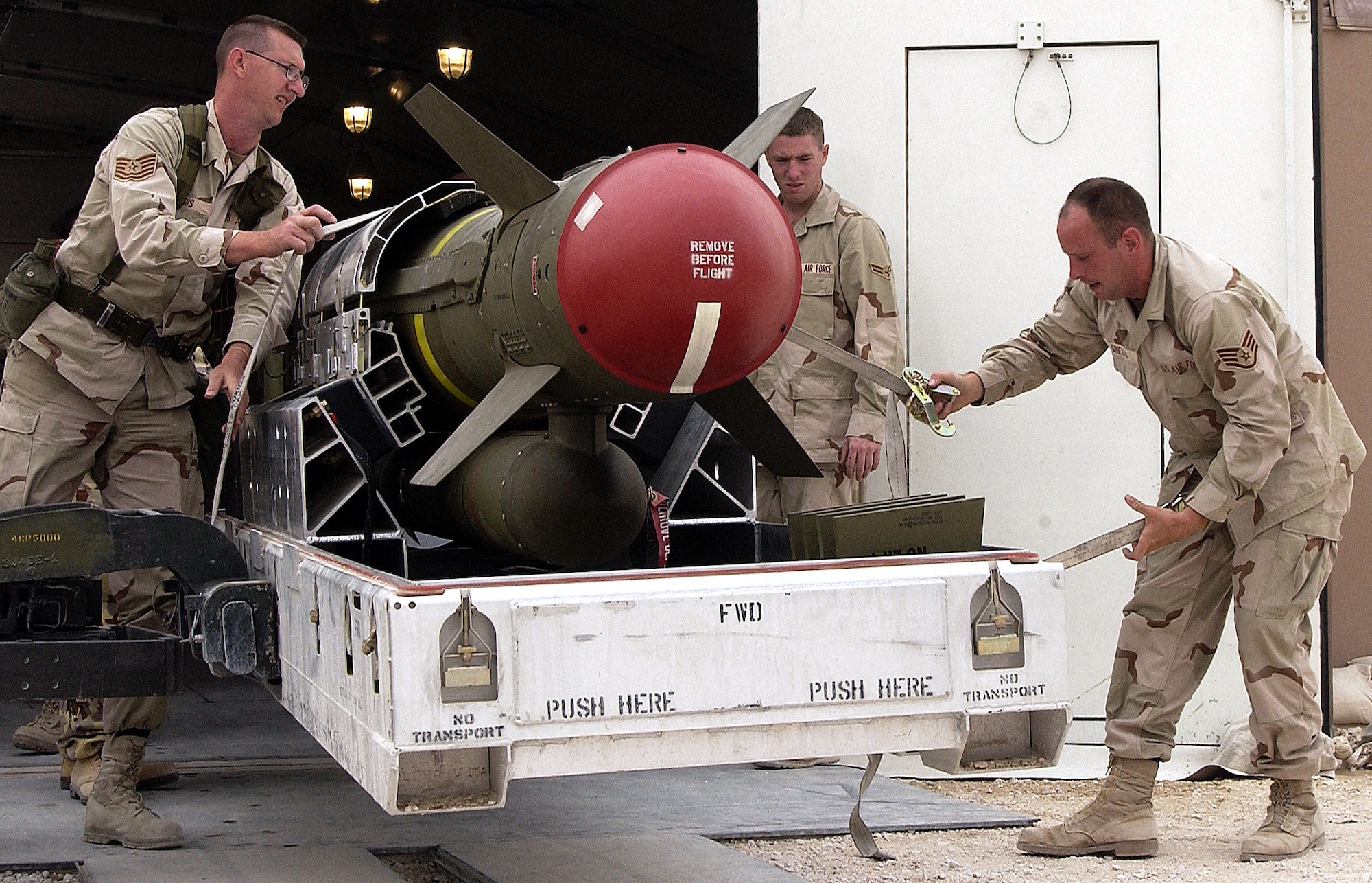 OPERATION IRAQI FREEDOM -- Members of the 379th EMXX Squadron, roll out a AGM-130 bomb to be delivered to the flight line at this forward-deployed location on March 21, 2003. The 379th Ammo squadron has built more than 5,000 bombs in the past four weeks for aircraft in support of Operation Enduring Freedom. (U.S. Air Force photo by Staff Sgt. Derrick C. Goode)