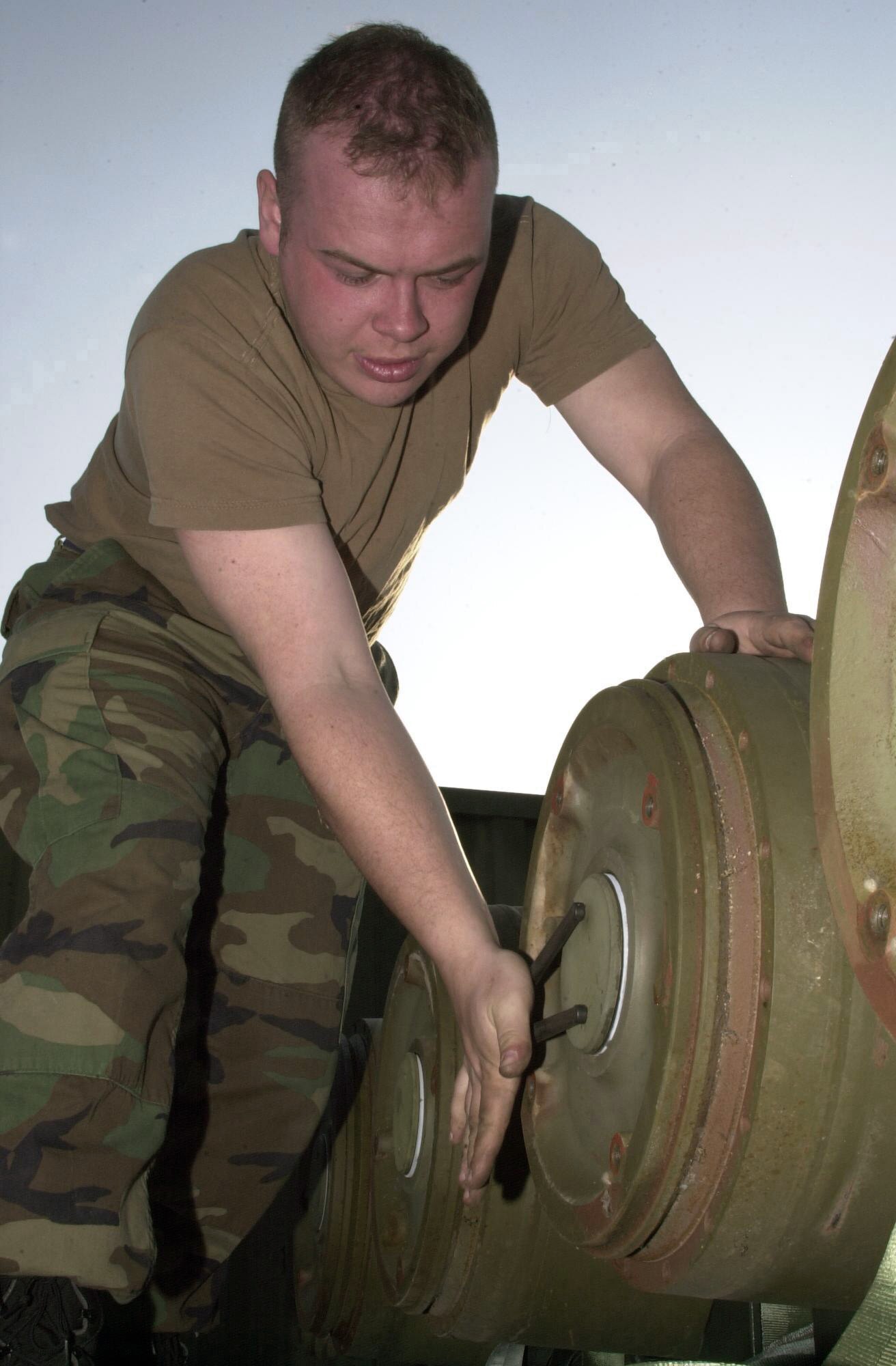 OPERATION IRAQI FEEDOM -- Senior Airman Josh Vader, from the 5th Expeditionary Maintenance Squadron's munitions flight, prepares an MK-84 "dumb bomb" for transition to a GBU-31 Joint Direct Attack Munition "smart bomb." Four components are added to the MK-84 turning it into a precision Global Positioning System-guided weapon.  (U.S. Air Force photo by Staff Sgt. Kristina Barrett)