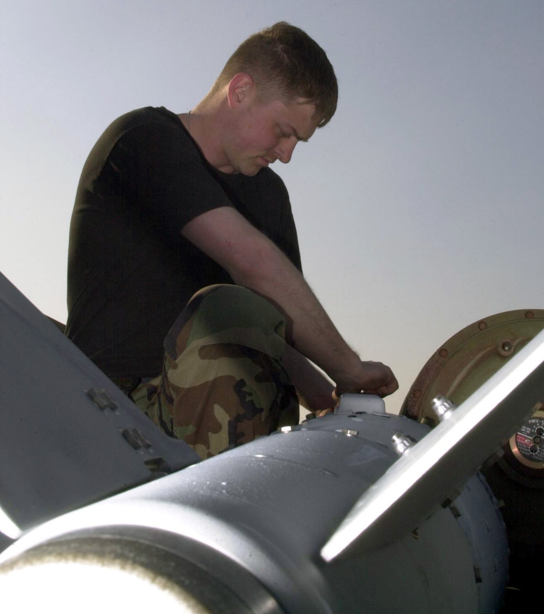 OPERATION IRAQI FEEDOM -- Airman 1st Class Richard Ludlum, from the 5th Expeditionary Maintenance Squadron's munitions flight, prepares an MK-84 "dumb bomb" for transition to a GBU-31 Joint Direct Attack Munition "smart bomb." Four components are added to the MK-84 turning it into a precision Global Positioning System-guided weapon.  (U.S. Air Force photo by Staff Sgt. Kristina Barrett)