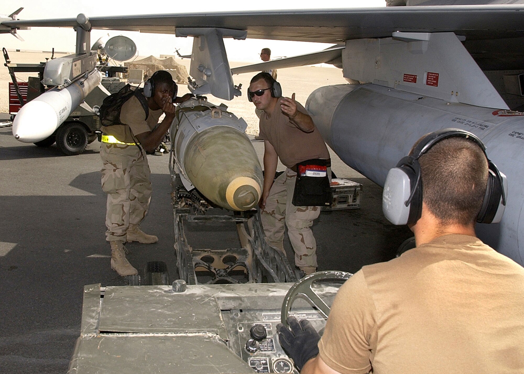 OPERATION IRAQI FREEDOM -- A weapons load crew, 22nd Expeditionary Fighter Squadron, load a GBU-31 bomb on an F-16CJ from Spangdalem Air Base, Germany before a mission on March 24, 2003 The F-16CJs are assigned to this forward-deployed air base in support of Operation Iraqi Freedom. (U.S. Air Force photo by Staff Sgt. Derrick C. Goode)      