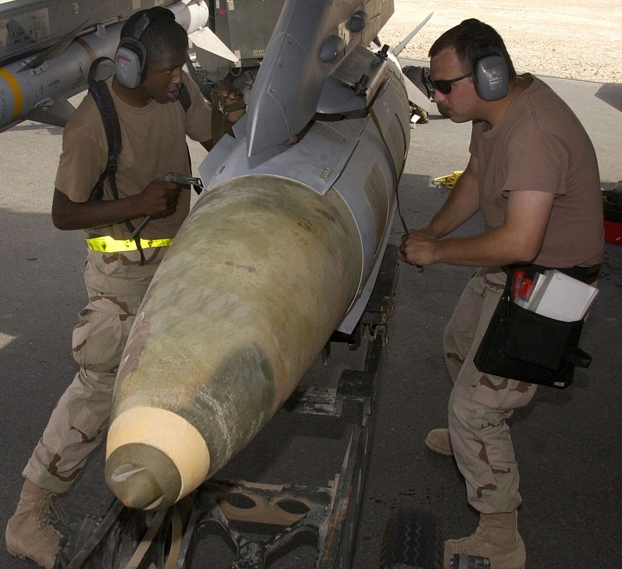 OPERATION IRAQI FREEDOM -- A weapons load crew from the 22nd Expeditionary Fighter Squadron loads a GBU-31 precision-guided bomb on an F-16 Fighting Falcon on March 24 at a forward-deployed Operation Iraqi Freedom air base. (U.S. Air Force photo by Staff Sgt. Derrick C. Goode)                            