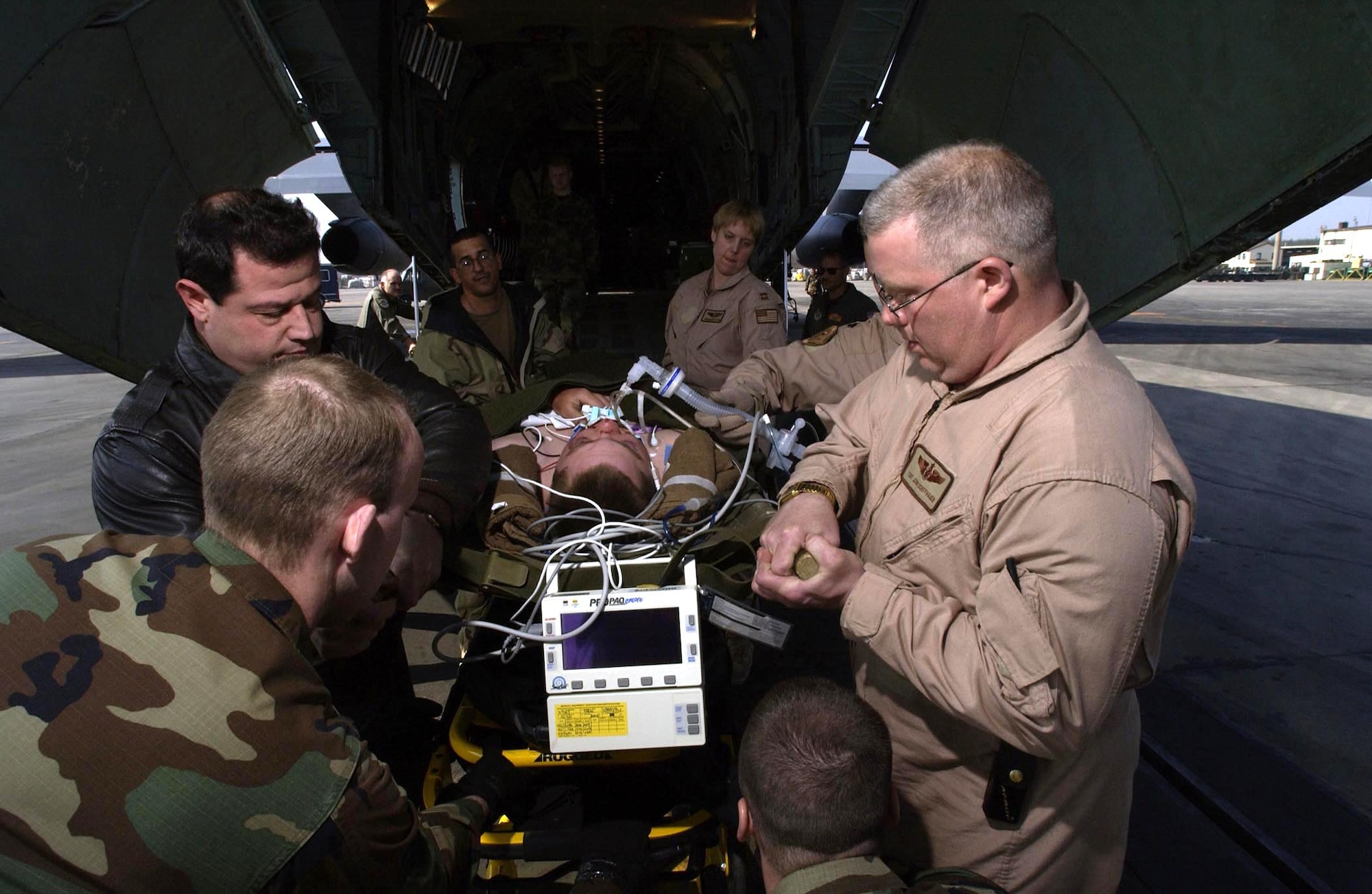 RAMSTEIN AIR BASE, Germany -- Tech. Sgt. John Schiffhauer (right) of the 932nd Aeromedical Evacuation Squadron at Scott Air Force Base, Ill., and members of the 86th Aeromedical Staging Facility here unload a wounded soldier from a C-141 Starlifter on March 24. Twelve soldiers wounded during Operation Iraqi Freedom were evacuated to Germany for additional medical treatment. (U.S. Air Force photo by Tech. Sgt. Justin D. Pyle)            