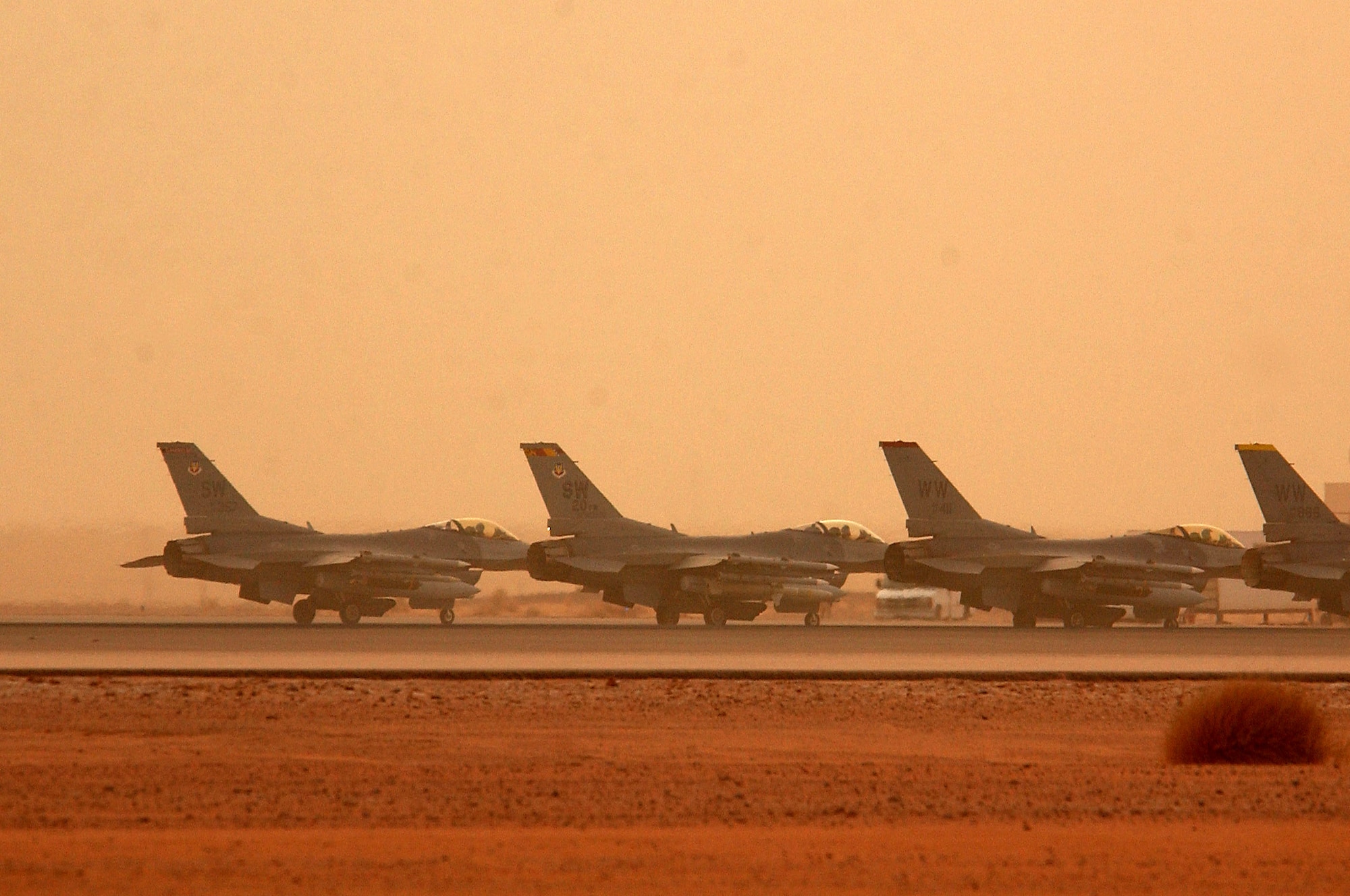 OPERATION IRAQI FREEDOM -- Four F-16 Fighting Falcons deployed to the 363rd Air Expeditionary Wing wait their turn to takeoff for a mission during a sand storm March 25.  Aircraft fly Operation Iraqi Freedom missions around the clock from a forward-deployed location in Southwest Asia.  (U.S. Air Force photo by Staff Sgt. Matthew Hannen)
