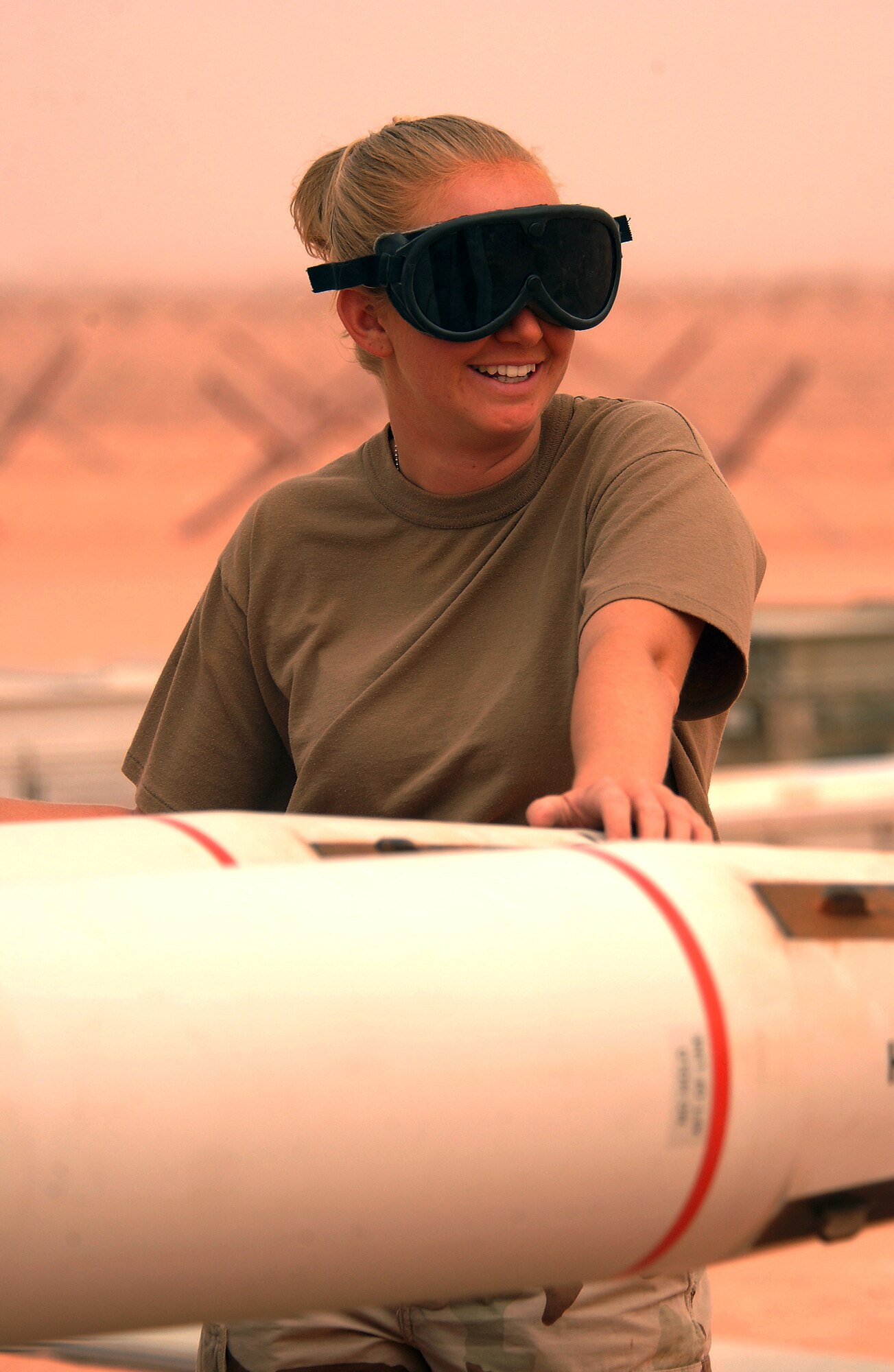 OPERATION IRAQI FREEDOM (AFPN) -- Senior Airman Lisa Jones loads air-to-ground missiles for an F-16 Fighting Falcon on the flightline at a forward-deployed location March 25.  Jones is a precision-guided munitions crew member with the 363rd Expeditionary Equipment Maintenance Squadron.  She is deployed from the 18th Fighter Squadron at Kadena Air Base, Japan.  (U.S. Air Force photo by Staff Sgt. Matthew Hannen) 
