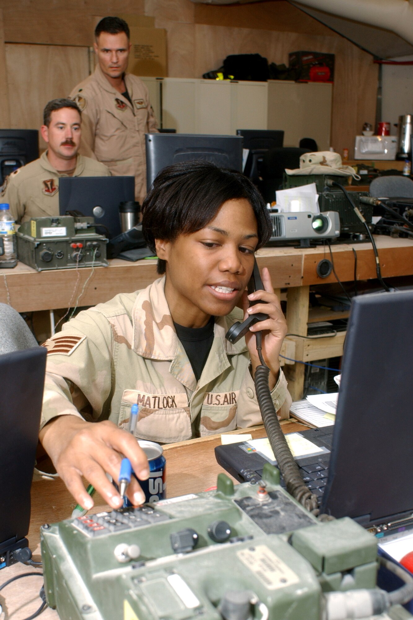 OPERATION IRAQI FREEDOM -- Staff Sgt. Selena Matlock tracks aircraft take off and landing times at the Coalition Operations Center, ensuring Air Tasking Orders are updated.  In the background, Lt. Col. Joseph Justice (standing) and Maj. David Wright, Coalition Operations Center directors, coordinate the flying schedule.  All are assigned to the 379th Air Expeditionary Wing at a deployed location. (U.S. Air Force photo by Master Sgt. Terry Blevins)