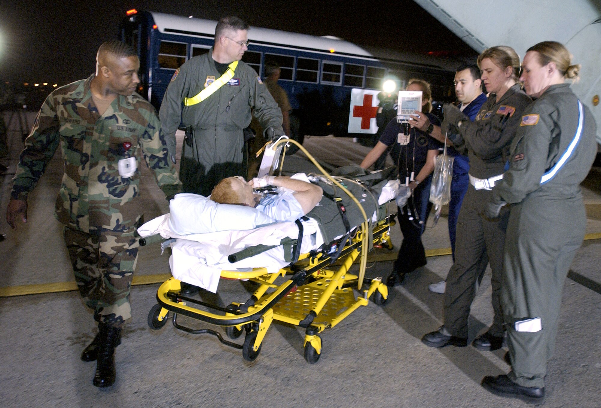 ANDREWS Air Force Base, Md. -- Crew members of the 491st Expeditionary Air Medical Evacuation Squadron carry one of 13 U.S. coalition force members wounded in the war in Iraq off of a C-141 Starlifter to a waiting ambulance here March 28, 2003.  The 13 patients, made up of two airmen, one sailor, four Marines and six soldiers, are the first wounded in the war in Iraq to arrive in the United States. They were flown in from Landstuhl Hospital, Ramstein Air Base, Germany, for treatment at Walter Reed Army Medical Center in Washington, D.C. and Bethesda Naval Medical Center in Rockville, Md.  The 491st EAMES is made up of Air Force Reservists from McGuire Air Force Base, N.J., and McChord Air Force Base, Wash.,  (U.S. Air Force photo by Tech. Sgt. Jim Varhegyi)