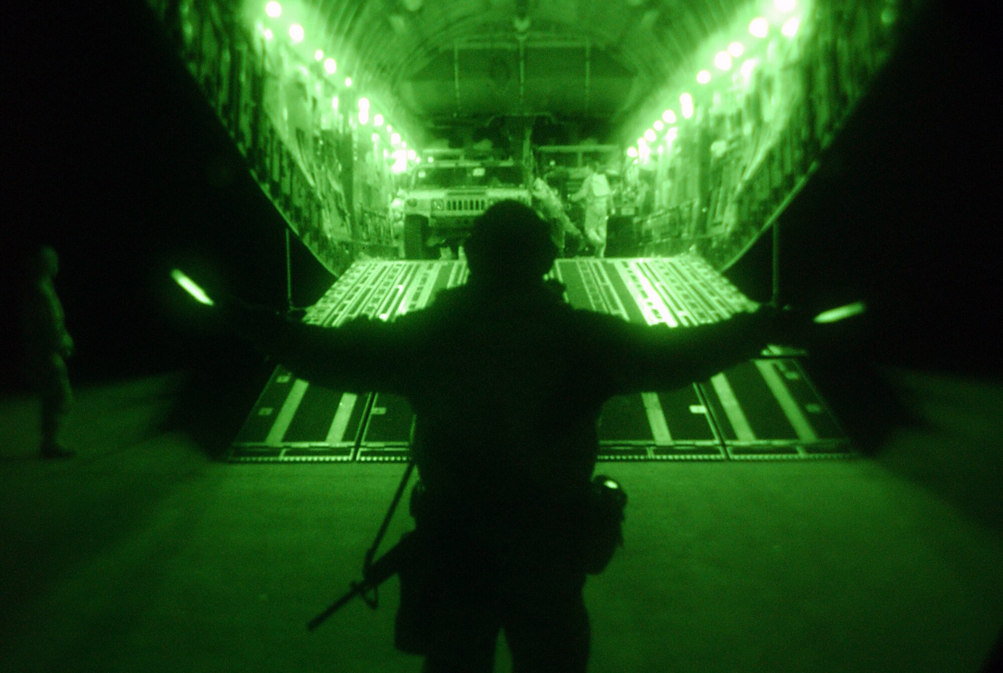 OPERATION IRAQI FREEDOM -- Master Sgt. Gerritt McCrory of the 86th Expeditionary Contingency Response Group marshals cargo and people from a C-17 Globemaster III aircraft during night operations March 30 at an airfield in northern Iraq.  (U.S. Air Force photo by Tech. Sgt. Rich Puckett)