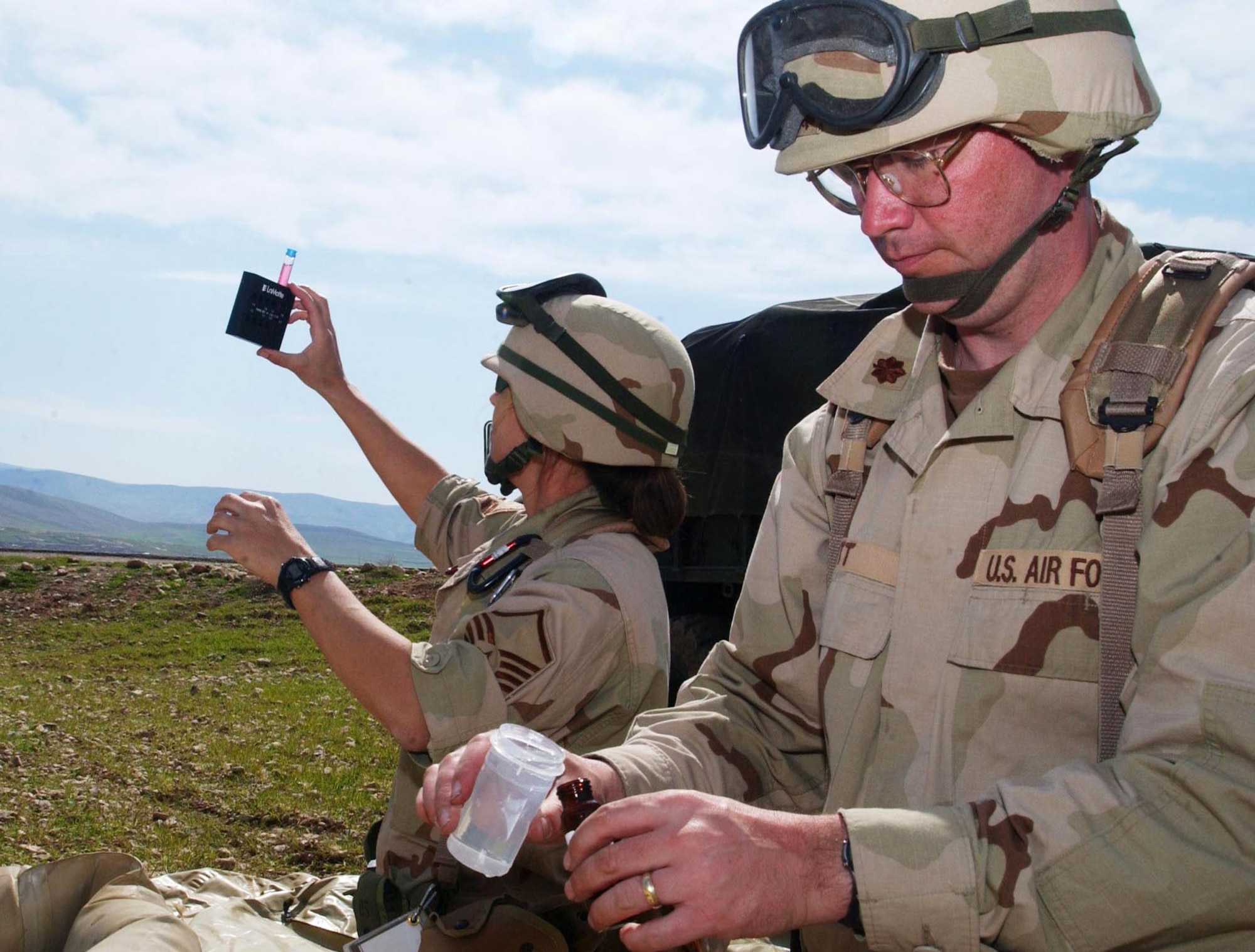 OPERATION IRAQI FREEDOM -- Master Sgt. Mindy Patrick (left) and Maj. Darrin Ott, of the 86th Expeditionary Contingency Response Group environmental medicine flight, take water samples for testing from a reverse osmosis treatment operation near an airfield in Northern Iraq on April 1.  Based at Ramstein Air Base, Germany, the unit's mission is to secure and prepare an airfield for flight operations.  (U.S. Air Force photo by Tech. Sgt. Rich Puckett) 