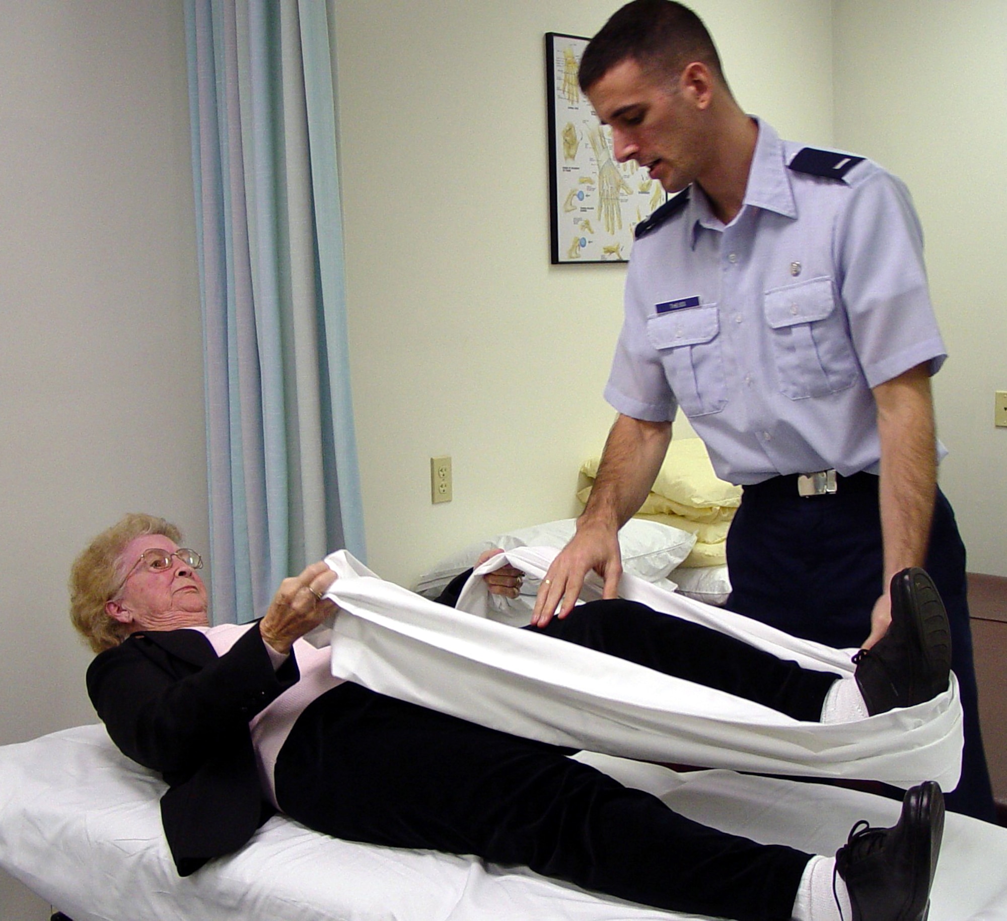 KEESLER AIR FORCE BASE, Miss. -- Physical therapist 1st Lt. Justin Theiss helps Maurine Maddox with a hamstring-stretching exercise she can do at home.  Osteoarthritis in her right knee makes it difficult for Maddox to sit and stand.  She began the regimen in January and within four weeks she was 95 percent improved.  (U.S. Air Force photo by Steve Pivnick)