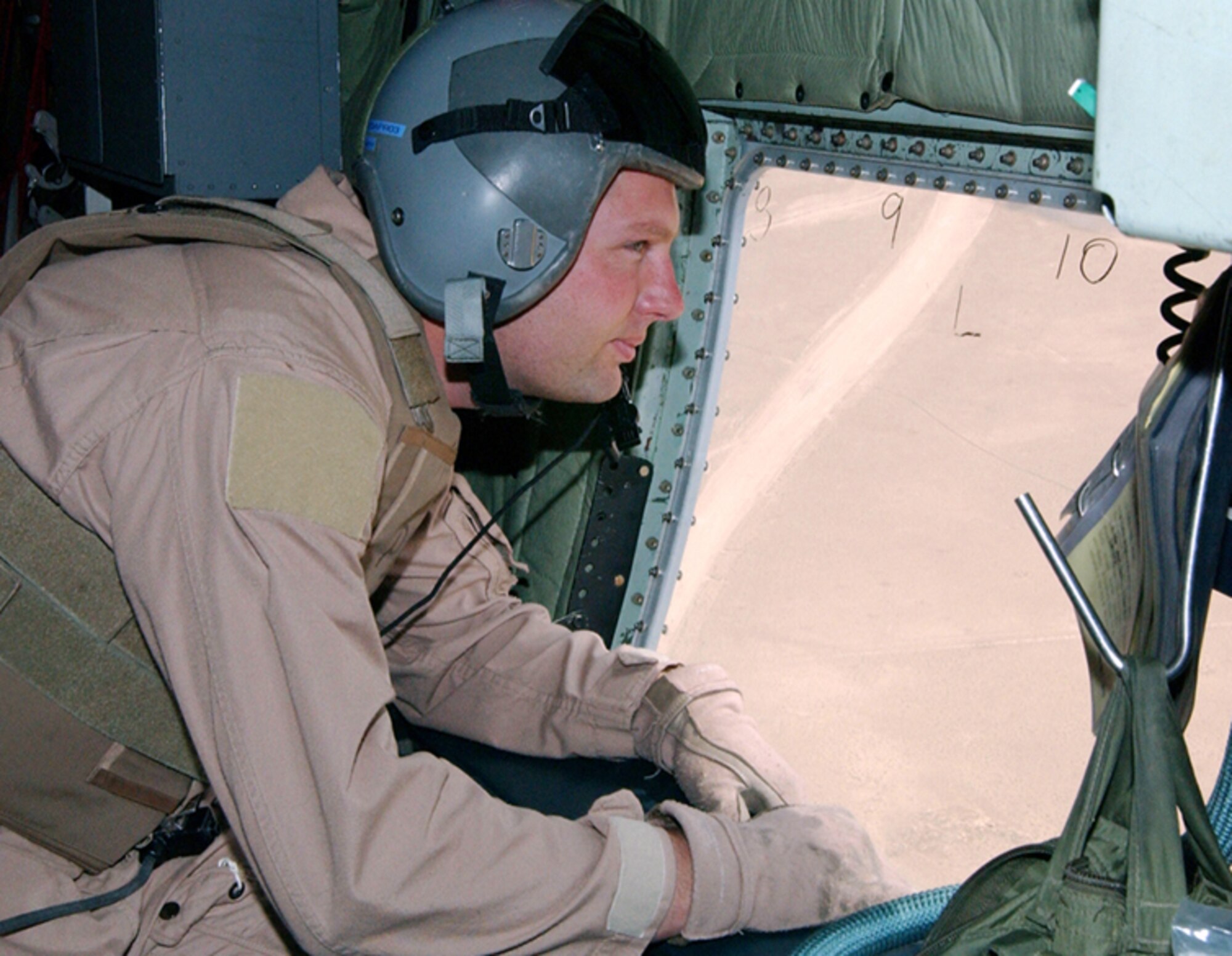 OPERATION IRAQI FREEDOM -- Master Sgt. Eric Draper scans the desert for possible threats as his HC-130 flies into a U.S.-controlled airfield in southern Iraq on April 3. Draper is a loadmaster with the 39th Rescue Squadron from Patrick Air Force Base, Fla., deployed to support Operation Iraqi Freedom. (U.S. Air Force Photo by Master Sgt. Stefan Alford)