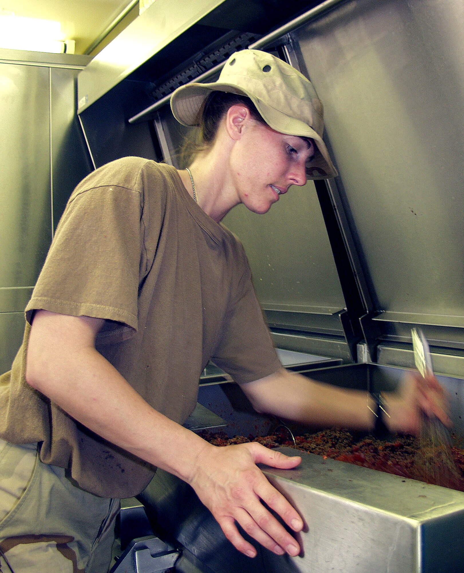 OPERATION IRAQI FREEDOM –- Inside a containerized deployable kitchen, Staff Sgt. Theresa Schaible mixes ingredients for Sloppy Joes. The 386th Expeditionary Services Squadron food services members feed thousands of military members several times daily. The kitchen always stays open, even in Alarm conditions, so that food will be available afterward. Operation Iraqi Freedom is the multinational coalition effort to liberate the Iraqi people, eliminate Iraq’s weapons of mass destruction and end the regime of Saddam Hussein. (U.S. Air Force photo)