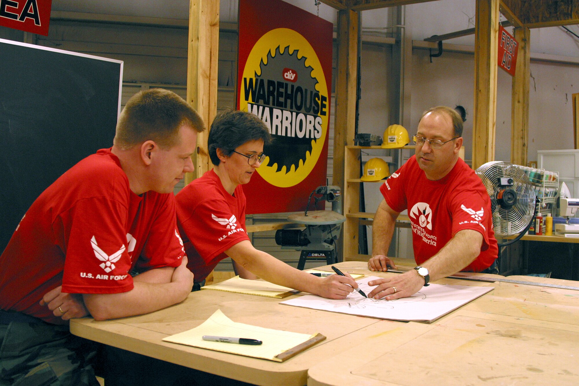 KNOXVILLE, Tenn. -- Members of the U.S. Air Force Band of Mid-America, (from left to right) Senior Airman Tom Money, Master Sgt. Connie Galbraith and Master Sgt. Paul Demerath, started their display case project by drafting design concepts.  The Band of Mid-America, from Scott Air Force Base, Ill., and the U.S. Air Force Band of the Golden West, from Travis AFB, Calif., each sent a three-person team here April 4, to participate in the Do-It-Yourself Network television show, Warehouse Warriors. (Courtesy photo)