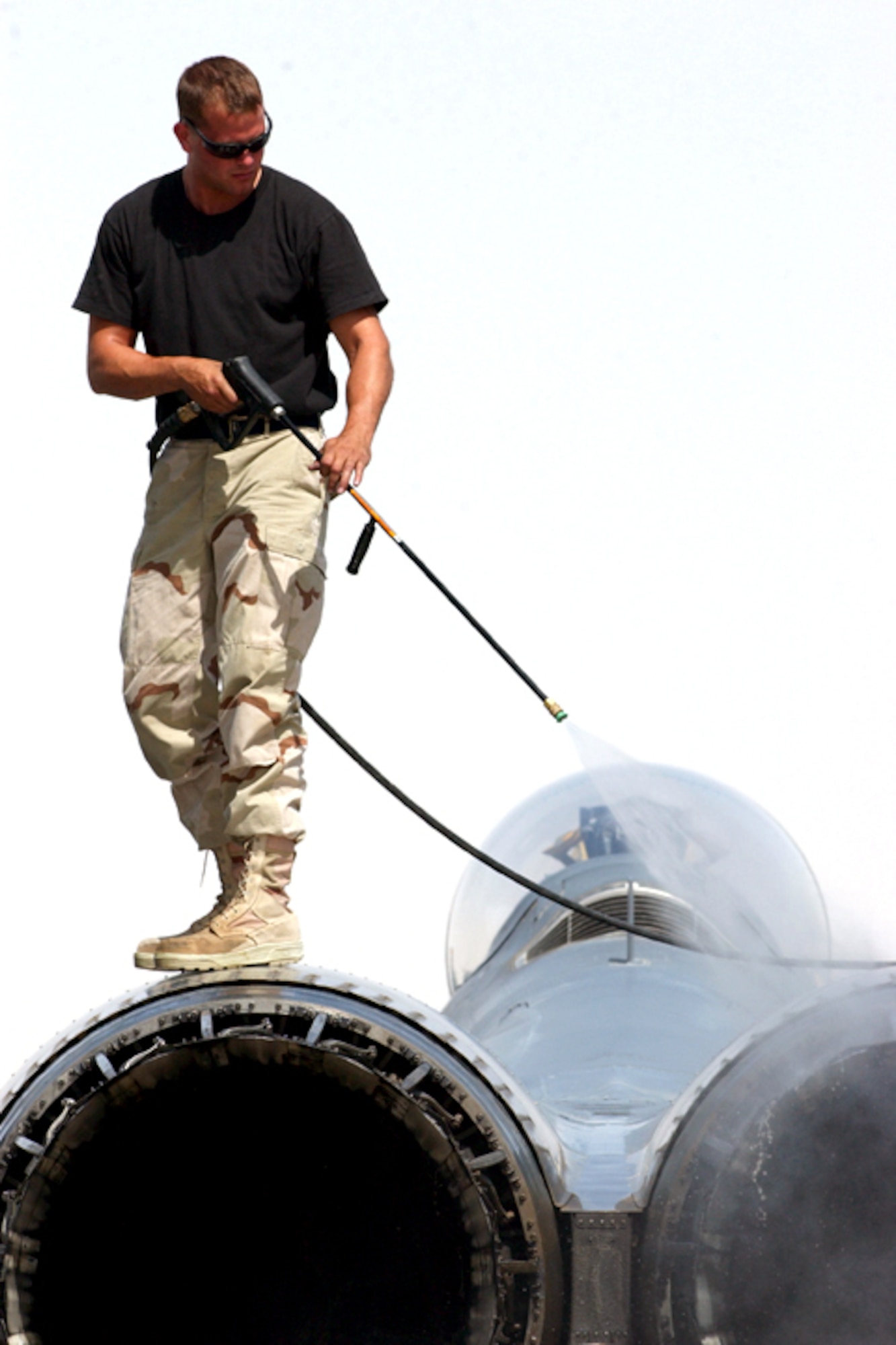 OPERATION IRAQI FREEDOM -- Staff Sgt. Michael Mariner washes down an F-15E Strike Eagle on April 5 to reduce the dust and dirt on the aircraft.  Mariner is a crew chief with the 379th Air Expeditionary Wing at a forward-deployed location supporting Operation Iraqi Freedom. (U.S. Air Force photo by Master Sgt. Terry L. Blevins)
