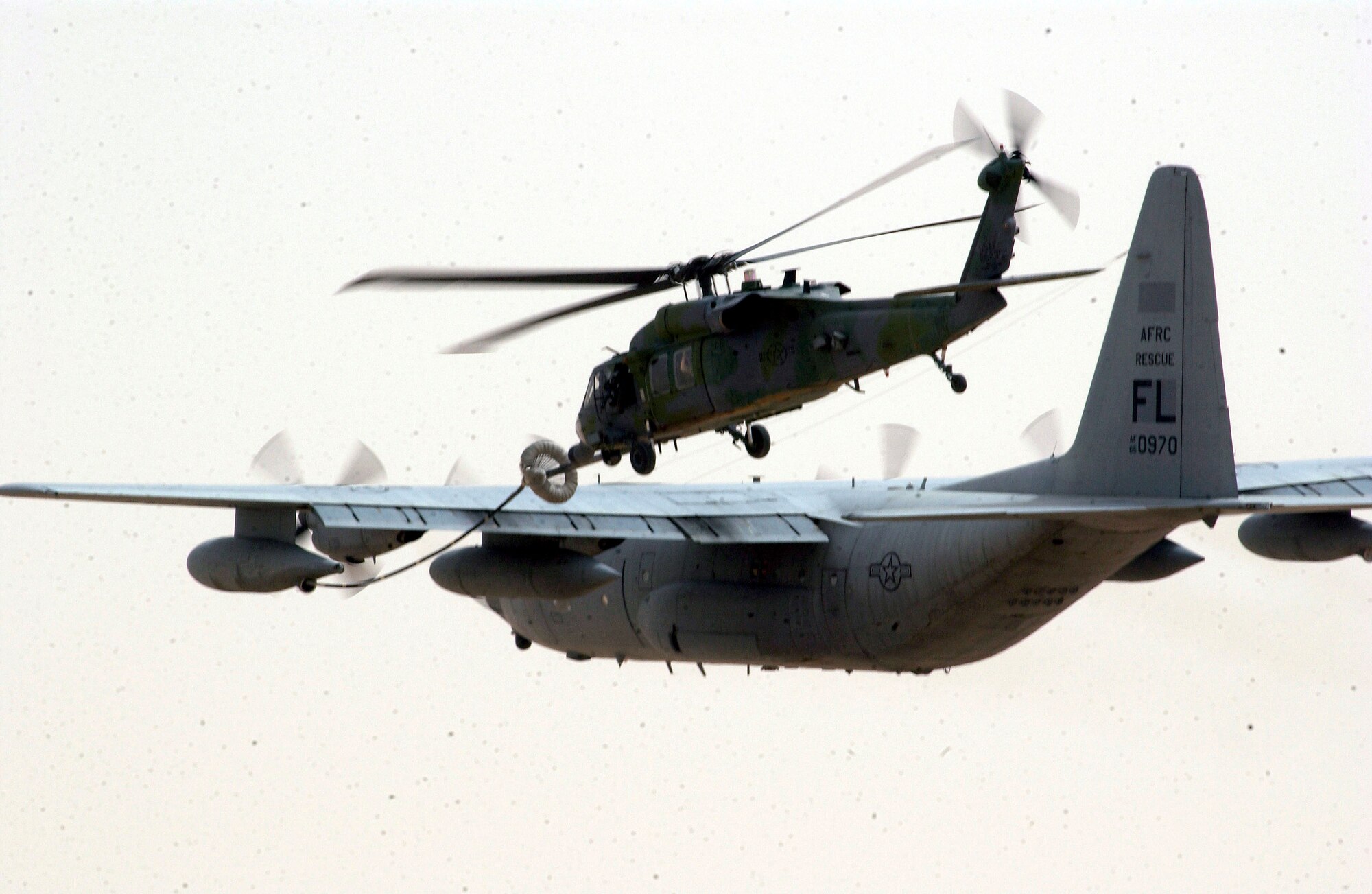 OPERATION IRAQI FREEDOM -- A Special Operations HH-60G Pave Hawk and C-130 Hercules from the 301st Rescue Squadron conduct an aerial refueling April 6 at a forward deployed location in southern Iraq during Operation Iraqi Freedom.  Operation Iraqi Freedom is multi-national coalition effort to liberate the Iraqi people, eliminate Iraq's weapons of mass destruction and bring an end to the regime of Saddam Hussein. (U.S. Air Force photo by Staff Sgt. Shane A. Cuomo)

