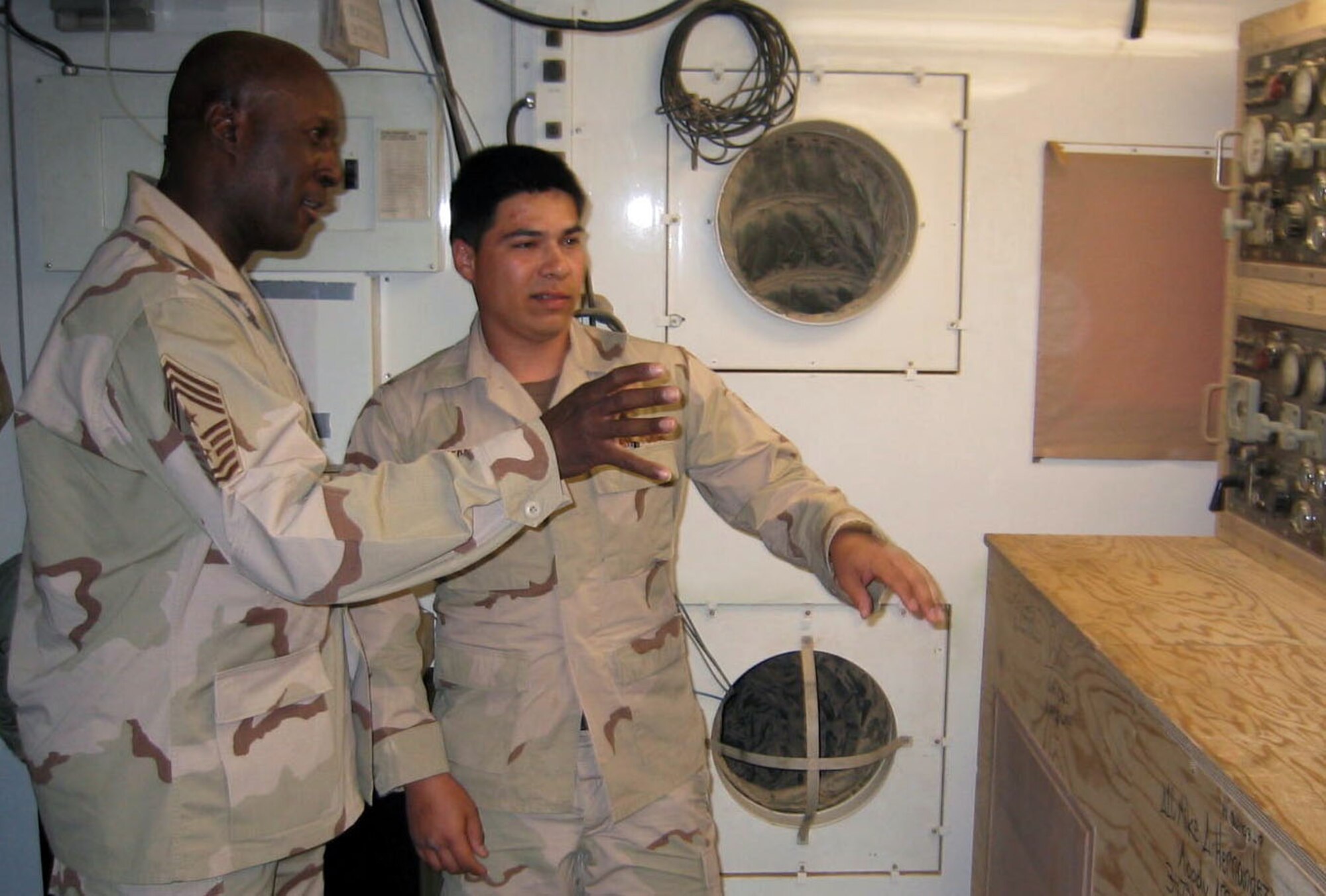 OPERATION IRAQI FREEDOM -- Airman 1st Class Manuel Hernandez shows Chief Master Sgt. Mack Williams the inside of the 444th Air Expeditionary Group's power plant during the chief's visit to a desert air base supporting Operation Iraqi Freedom on April 6.  The U.S. Central Command Air Forces command chief master sergeant travels regularly throughout the region. Hernandez is a power plant production apprentice from Moody Air Force Base, Ga.  (U.S. Air Force photo by Master Sgt. Charles Ramey)