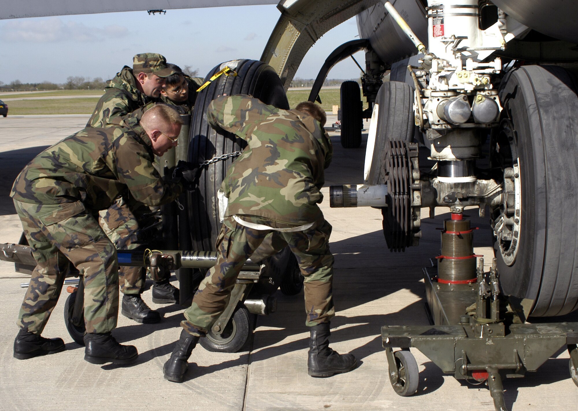 OPERATION IRAQI FREEDOM -- Staff Sgt. Randy Simmons and Senior Airmen Benjamin David, Steven Campos and Matthew Easton push a fresh B-52 Stratofortress tire toward its mount April 7 at a forward-deployed location.  Two or three of the 500-pound tires get changed each day.  The old tire is removed and then bled of its air.  The new four-foot tall tire is then mounted in place.  The whole process takes about 20 minutes for each tire.  (U.S. Air Force photo by Tech. Sgt. Jason Tudor)