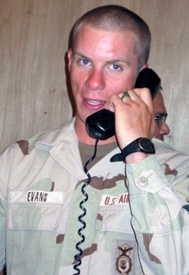 OPERATION IRAQI FREEDOM -- Wearing a makeshift wedding band, Senior Airman James Evans speaks to his new wife, Andrea, following their marriage by proxy ceremony.  Evans is a security forces airman currently deployed with the 444th Air Expeditionary Group.  (U.S. Air Force photo by Master Sgt. Charles Ramey)