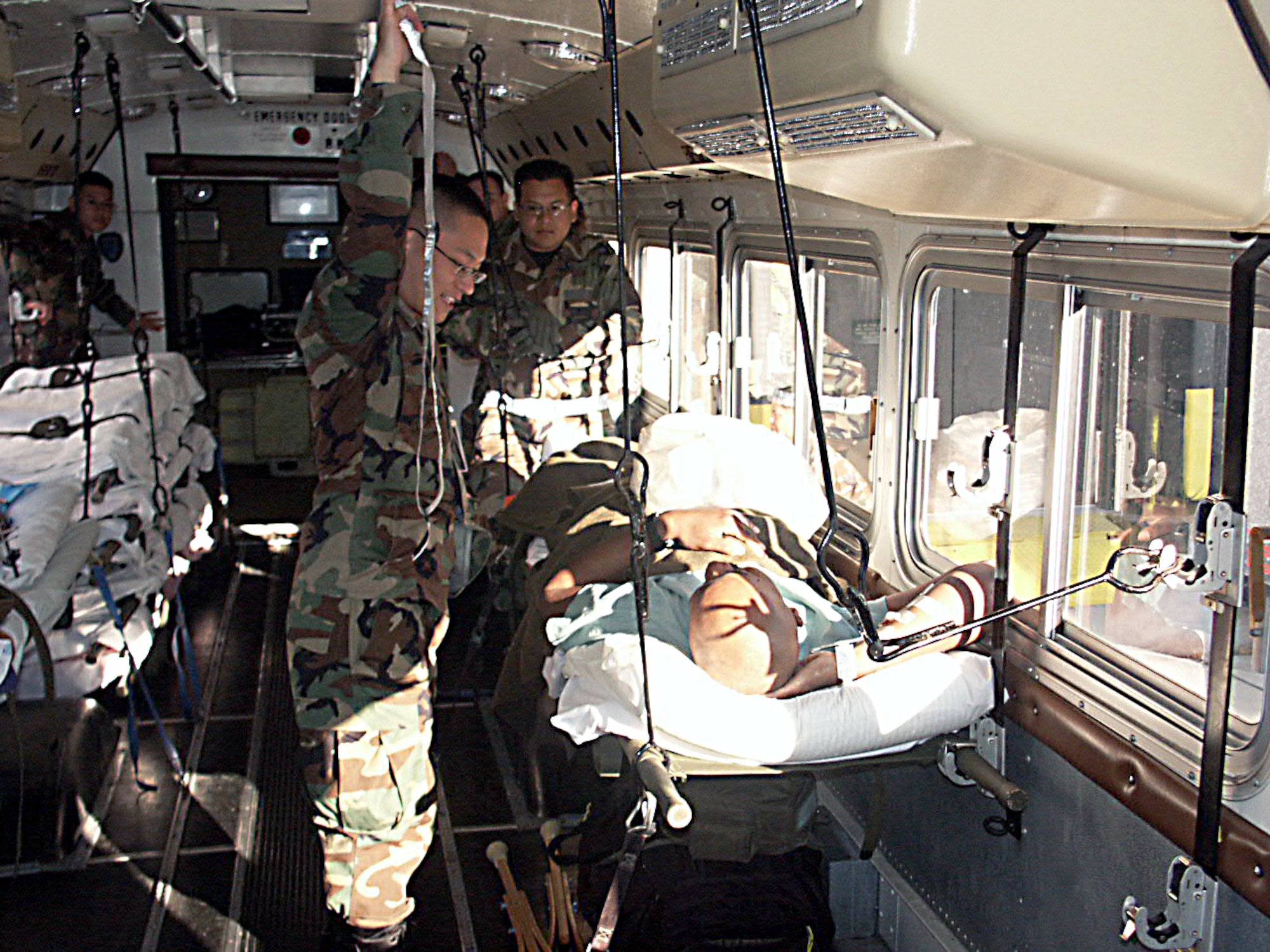 LACKLAND AIR FORCE BASE, Texas -- Senior Airman William K. Poon (left) checks on a servicemember injured in Operation Iraqi Freedom.  The patient was one of 47 brought here April 9.  (U.S. Air Force photo by Tech. Sgt. Steve Elliott)