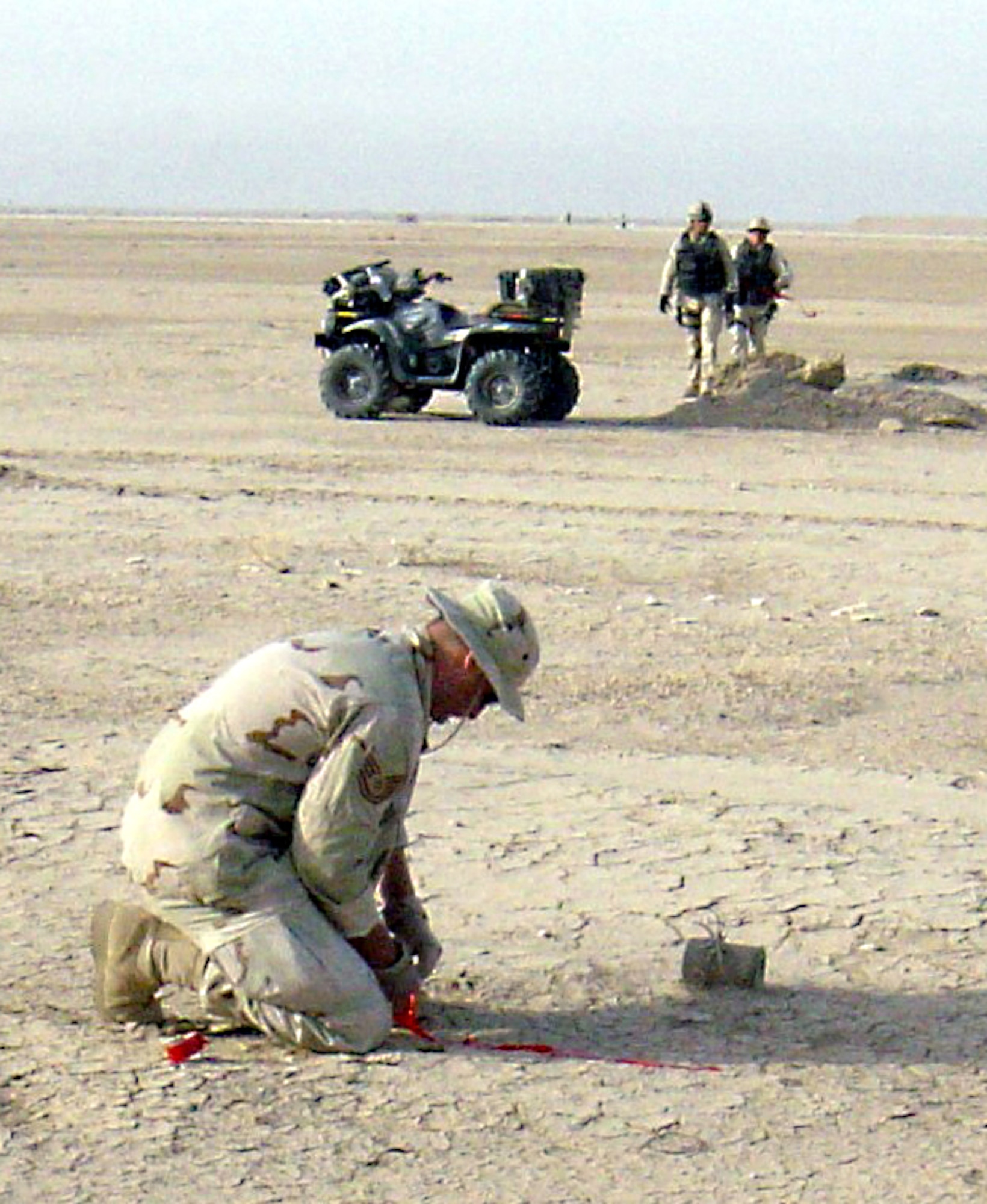 OPERATION IRAQI FREEDOM -- An Airborne Red Horse explosive ordnance technician marks an unexploded submunition at a seized airfield in Iraq.  He is a member of one of three new Airborne Red Horse teams that can be inserted into remote and inaccessible airfields by parachute or assault helicopter.  (Air Force photo by Master Sgt. Michael Haque)
