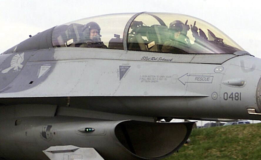 SPANGDAHLEM AIR BASE, Germany -- Capt. Jessica Rhyne, 23rd Fighter Squadron pilot, makes the “big guns” gesture as she and 1st Lt. Corinne Gilliam, 23rd FS Intelligence Flight officer, prepare for flight April 1. The captain and 1st Lt. Gilliam were part of a three-“man” flying training mission, which included Spangdahlem Air Base’s only other female F-16 pilot, 1st Lt. Leigh Noel, 22nd Fighter Squadron.  (U.S. Air Force photo by Staff Sgt. Karen Z. Silcott)