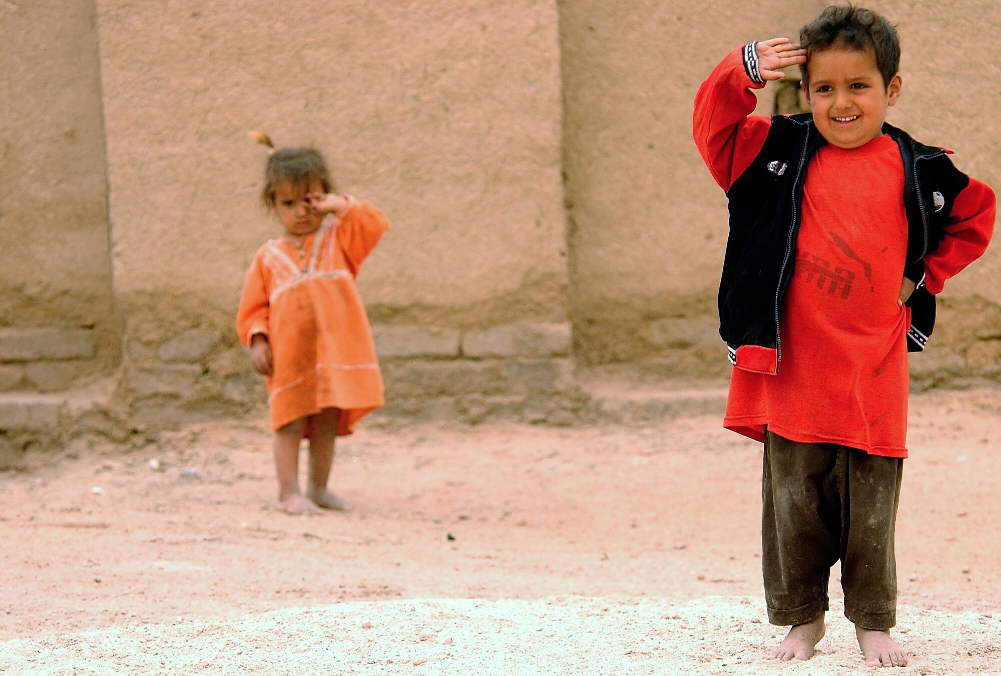 OPERATION IRAQI FREEDOM -- A young Iraqi boy salutes members of the 486th Civil Affairs Company as they deliver water to his village on April 11.  The 486th Civil Affairs Company, from Broken Arrow, Okla., is deployed to an undisclosed location in support of Operation Iraqi Freedom.  Operation Iraqi Freedom is a multi-national coalition effort to liberate the Iraqi people, eliminate Iraq's weapons of mass destruction and bring an end to the regime of Saddam Hussein.  
(U.S. Air Force photo by Staff Sgt. Quinton T. Burris)  
