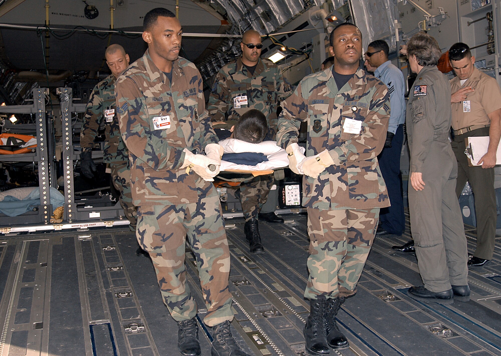 ANDREWS AIR FORCE BASE, Md. -- Medics from the 459th Aeromedical Evacuation Squadron carry an injured military member from a C-17 Globemaster III aircraft to an awaiting medical evacuation bus.  (U.S. Air Force photo by Bobby Jones)