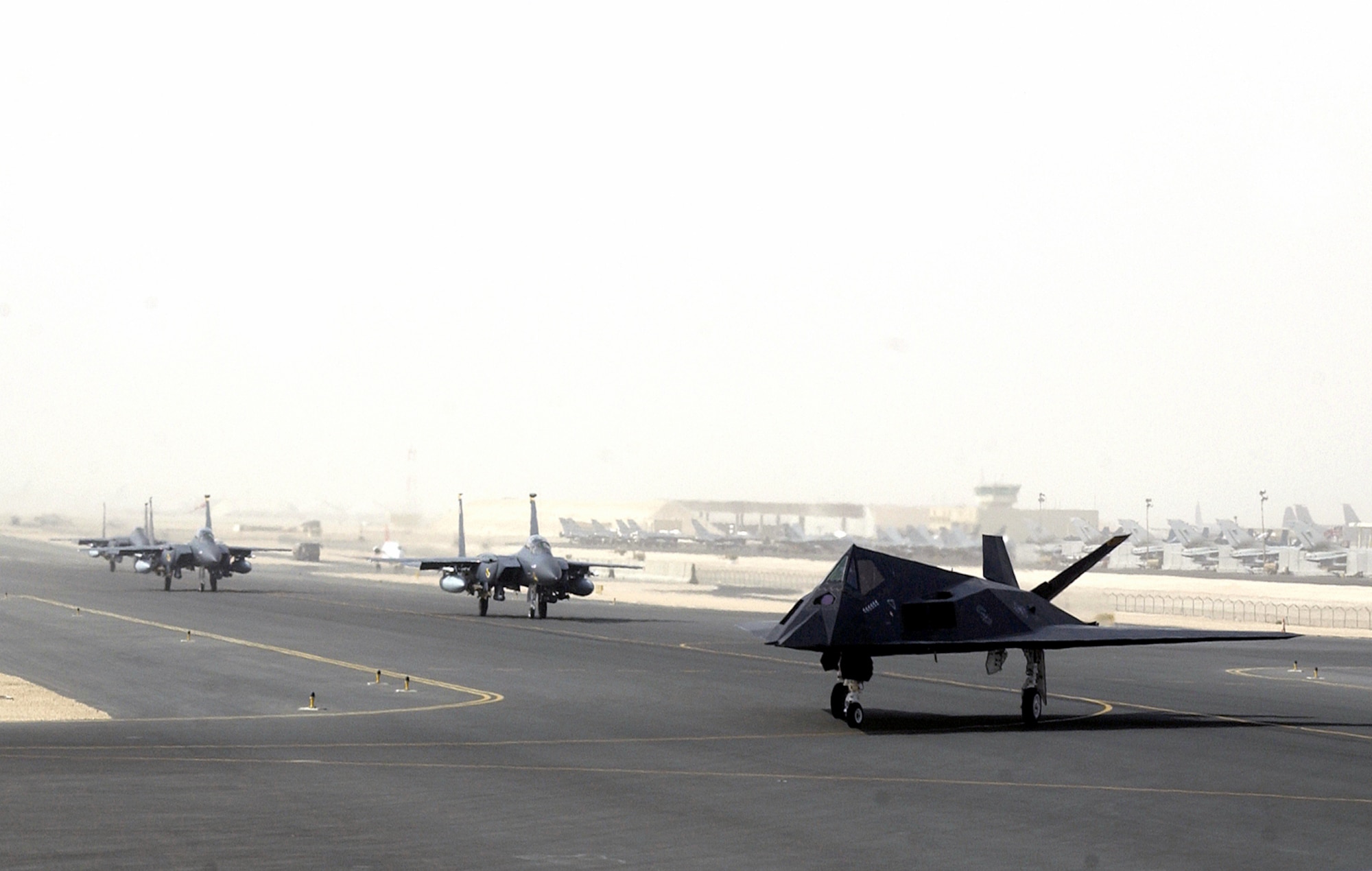OPERATION IRAQI FREEDOM -- An F-117 from the 8th Expeditionary Fighter Squadron out of Holloman A.F.B., NM, followed by F-15s from Seymour Johnson Air Force Base, N.C., prepare to launch from a forward-deployed air base in the Middle East on April 14, 2003. The 8th EFS has begun returning to Hollomann A.F.B. after having been deployed to the Middle East in support of Operation Iraqi Freedom. (U.S. Air Force photo by Staff Sgt. Derrick C. Goode)
