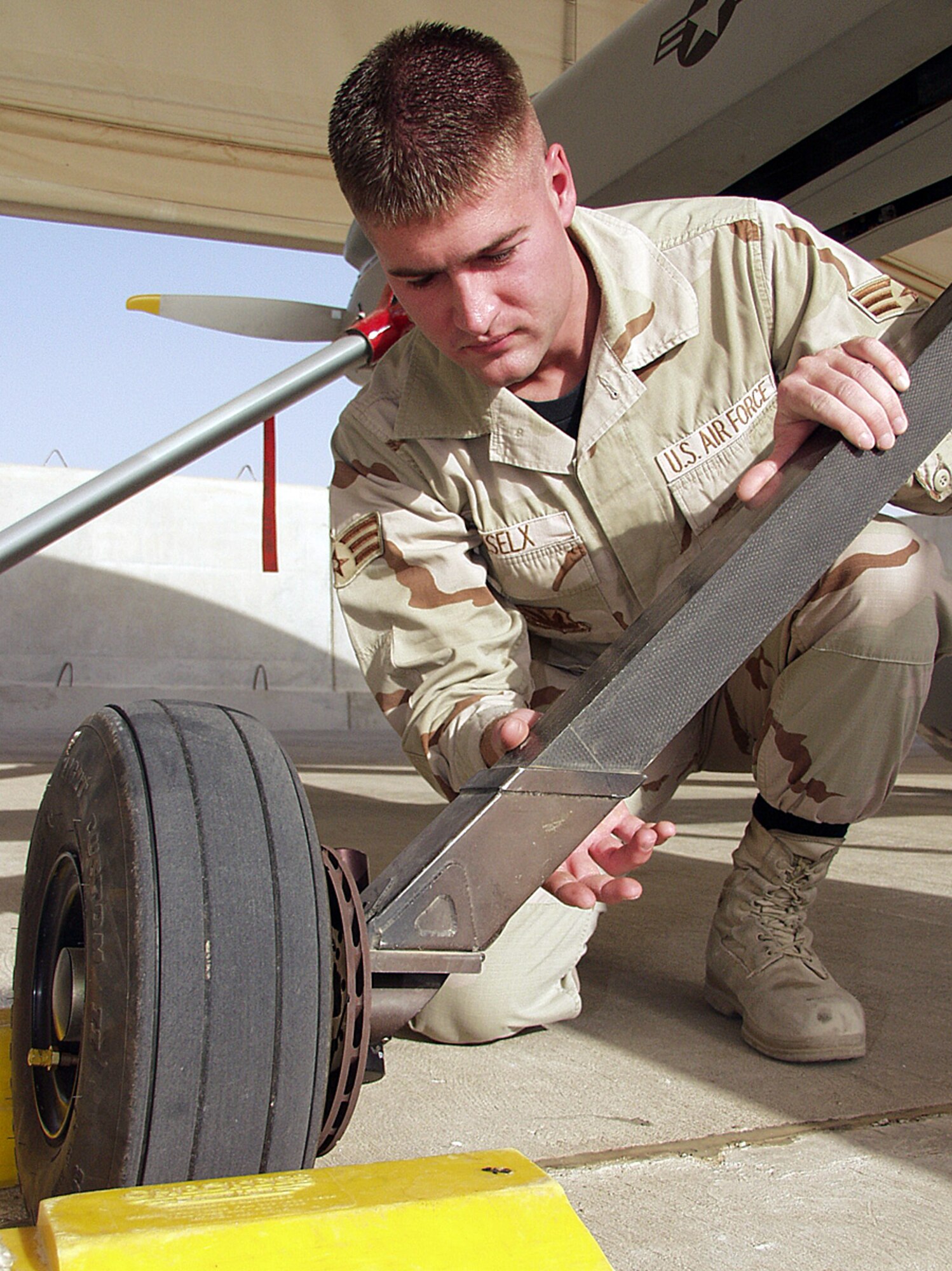 OPERATION IRAQI FREEDOM -- Senior Airman Jason Biselx, a 46th Expeditionary Reconnaissance Squadron crew chief, checks a brake assembly on one of the unit's MQ-1 Predator unmanned aerial vehicles during a preflight inspection.  Based at a forward-deployed location, the Predator unit is participating in Operation Iraqi Freedom.  (U.S. Air Force photo by Tech. Sgt. Dan Neely)