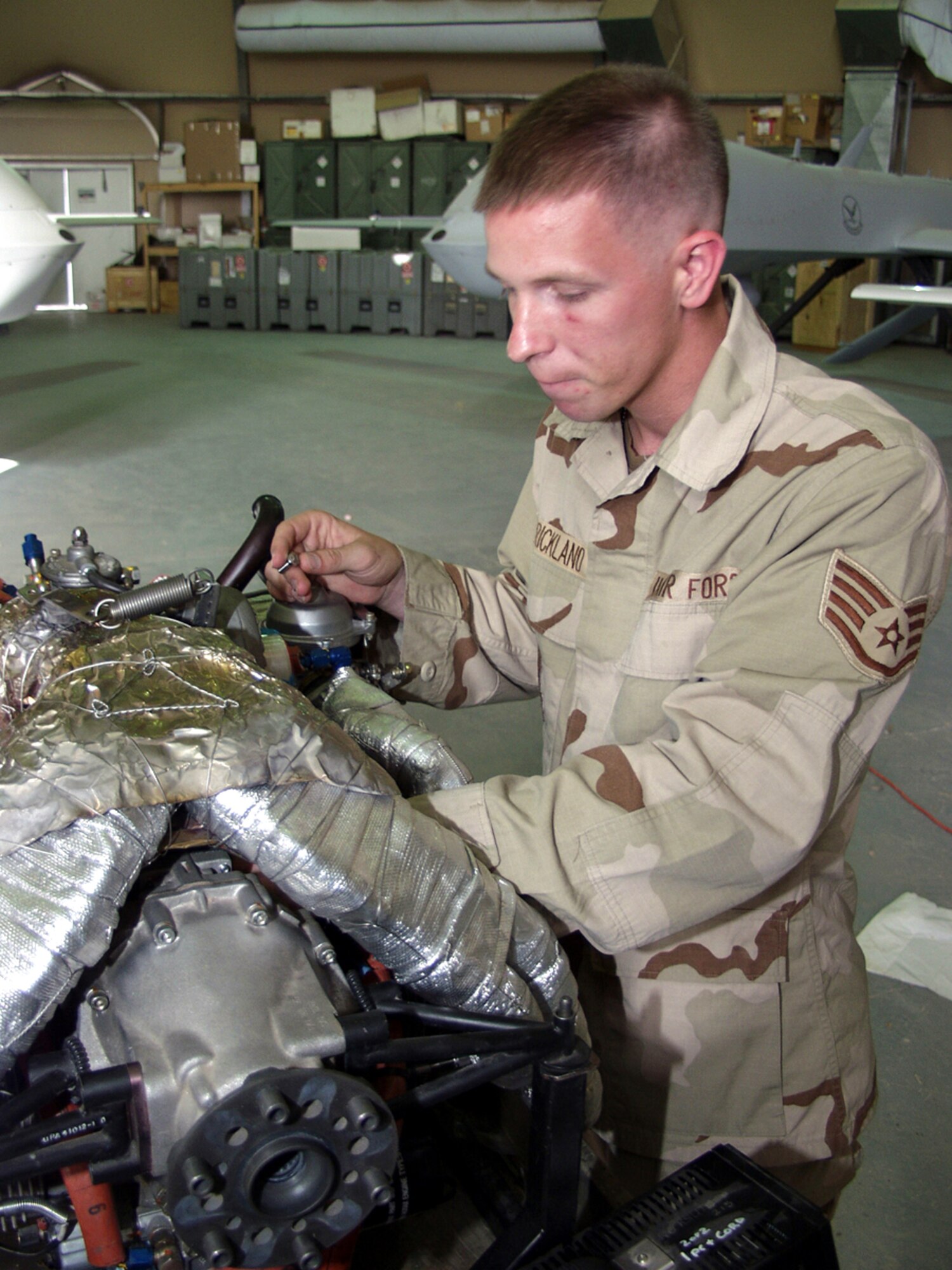 OPERATION IRAQI FREEDOM -- Staff Sgt. Kevin Strickland, 46th Expeditionary Reconnaissance Squadron maintenance crew chief, works on a Rotax 914 engine from an RQ-1 Predator unmanned aerial vehicle at a deployed location participating in Operation Iraqi Freedom.  His task was part of a time-phased engine overhaul procedure.  (U.S. Air Force photo by Tech. Sgt. Dan Neely)