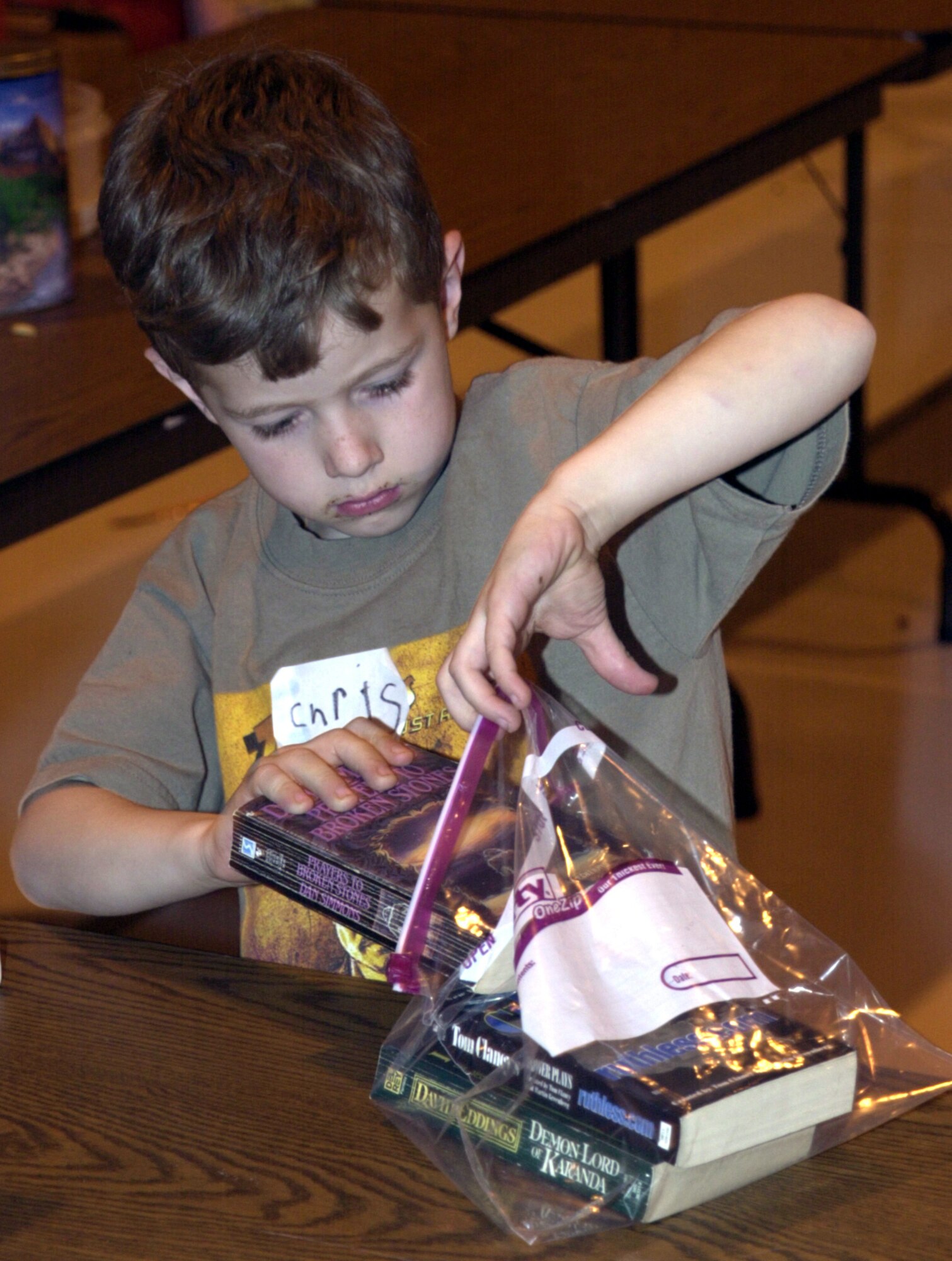 ANDREWS AIR FORCE BASE, Md. -- Chris Turner, age 6, puts books into a plastic bag that will be sent in a care package to his father’s deployed unit, the 113th Aircraft Generation Squadron, D.C. Air National Guard.  Master Sgt. Mike Turner and other members of the squadron have been deployed for nearly two months. Families of the D.C. ANG gathered April 12 at Andrews Air Force Base, Md., for a pot-luck dinner, children’s games and a chance to help relieve some of the stress associated with the deployment of a loved one. (U.S. Air Force photo by Staff Sgt. A.J. Bosker)
