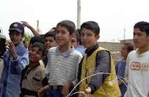 OPERATION IRAQI FREEDOM -- Driving through Kirkus, Iraq, Tech. Sgt. Steve Fausili took this photo of Iraqi boys waving at the passing American convoy.  Fausili is a combat cameraman assigned to the 1st Combat Camera Squadron at Charleston Air Force Base, S.C.  (U.S. Air Force photo by Tech. Sgt. Steve Fausili)