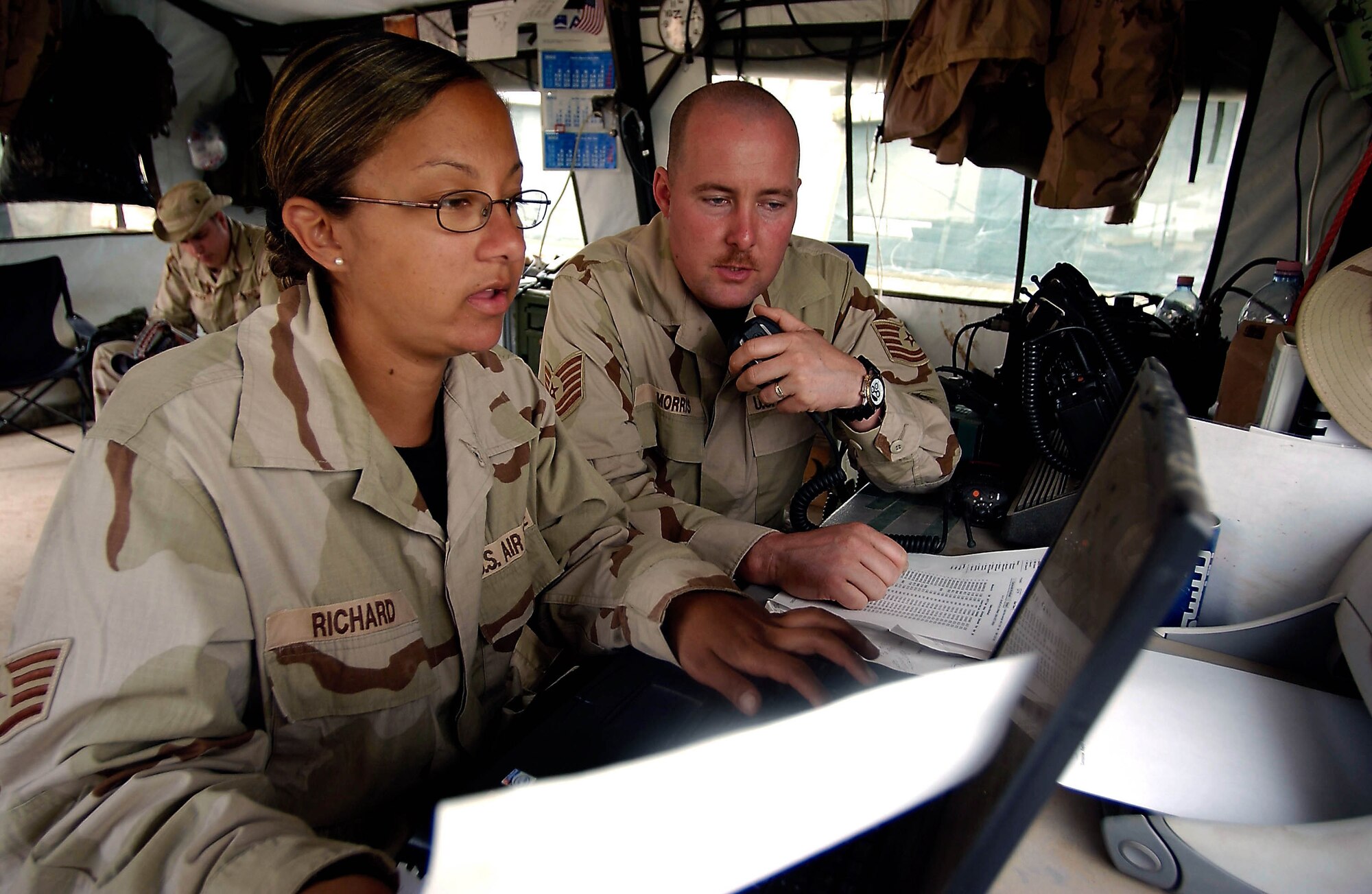 OPERATION IRAQI FREEDOM -- Staff Sgt. Marissa Richard, a tanker airlift control element manager, and Tech. Sgt. Jeffrey Morris, a command and control troop -- both with the 86th Expeditionary Air Mobility Squadron -- coordinate an aircraft arrival at Bashur Airfield, Iraq.  The squadron, part of the 86th Expeditionary Contingency Control Group, has runs the aerial port operations at the base. (U.S. Air Force photo)