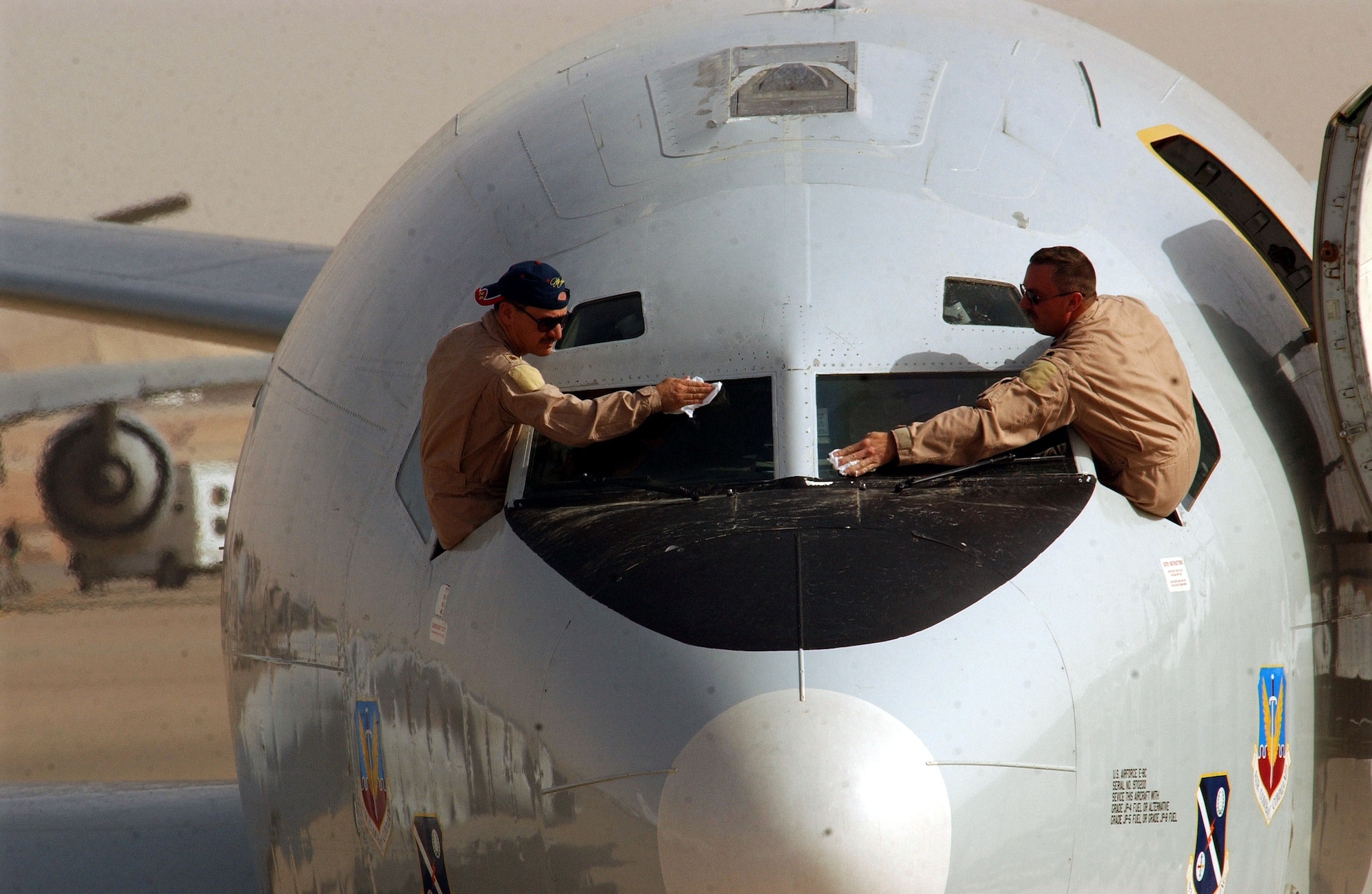 OPERATION IRAQI FREEDOM -- Maj. Robert Komlo and Lt. Col. Keith Turner, both E-8 Joint Surveillance Target Attack Radar System pilots deployed from the Georgia Air National Guard, clean their windshield before taking off for a mission April 21.  JSTARS aircraft fly missions 24 hours a day in support of Operation Iraqi Freedom at a forward-deployed location in Southwest Asia. (U.S. Air Force photo by Staff Sgt. Matthew Hannen)
