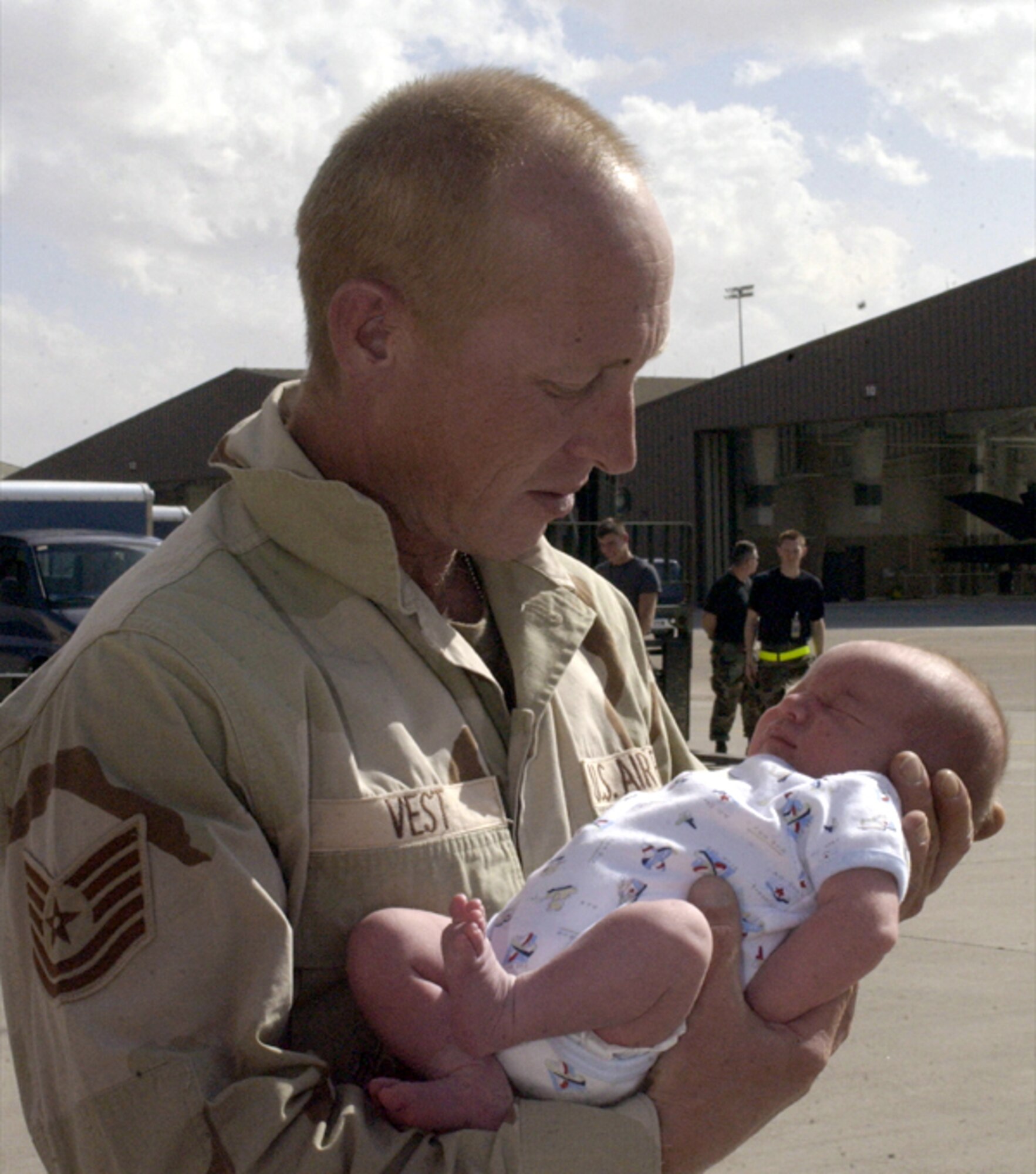 HOLLOMAN AIR FORCE BASE, N.M. -- Tech. Sgt. Joseph Vest, a support airman for the 8th Fighter Squadron here, meets his 1-week-old son, Joseph Jr., for the first time after returning from a deployment.  He was one of the airmen who returned April 17 after supporting Operation Iraqi Freedom.  About 300 people from Holloman AFB who deployed will return this month.  (U.S. Air Force photo by Airman 1st Class Vanessa LaBoy)