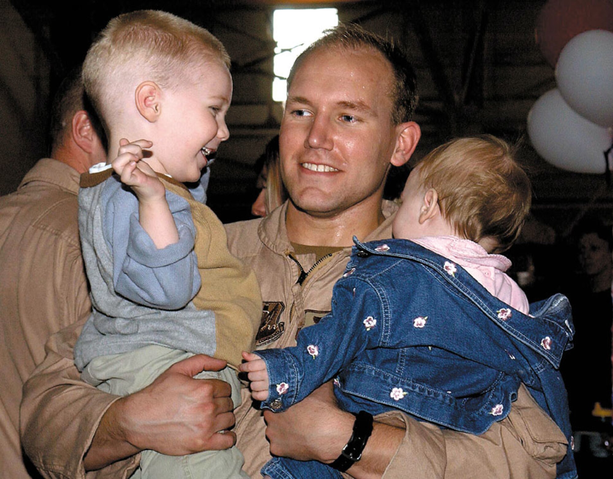 MINOT AIR FORCE BASE, N.D. -- Capt. Gary Berger, a 23rd Bomb Squadron electronic warfare officer, is welcomed home from serving in Operation Iraqi Freedom by his son, Vaughn, and his daughter, Ava.  (U.S. Air Force photo by Airman Alicia M. Sarkkinen)