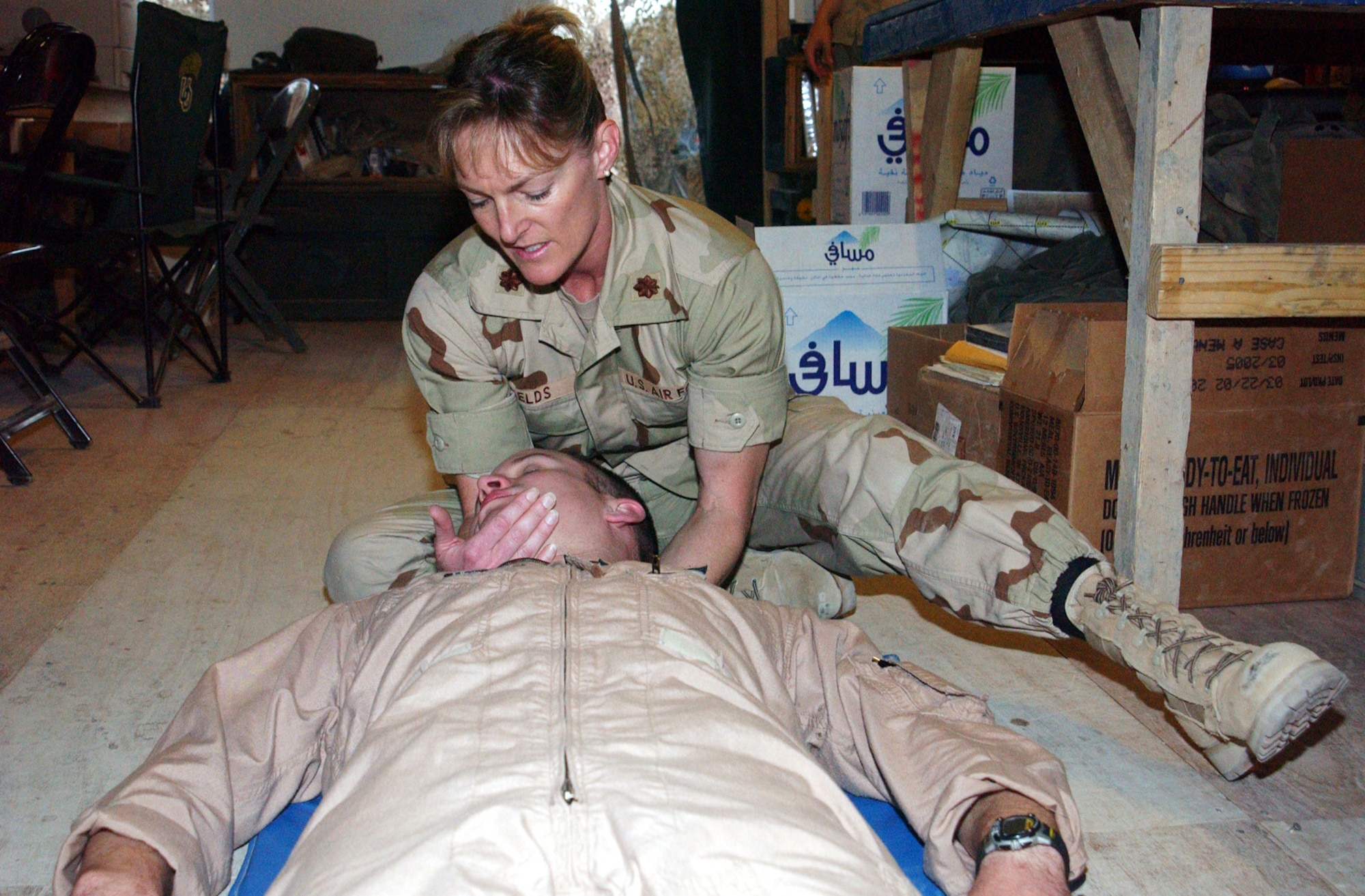OPERATION IRAQI FREEDOM -- Maj. Laura Fields works on stretching out a pilot's neck and shoulder muscles during a physical therapy team visit to a Marine flying squadron tent.  The team visits different flying units each night at the forward-deployed location supporting Operation Iraqi Freedom.  (U.S. Air Force photo by Master Sgt. Stefan Alford)