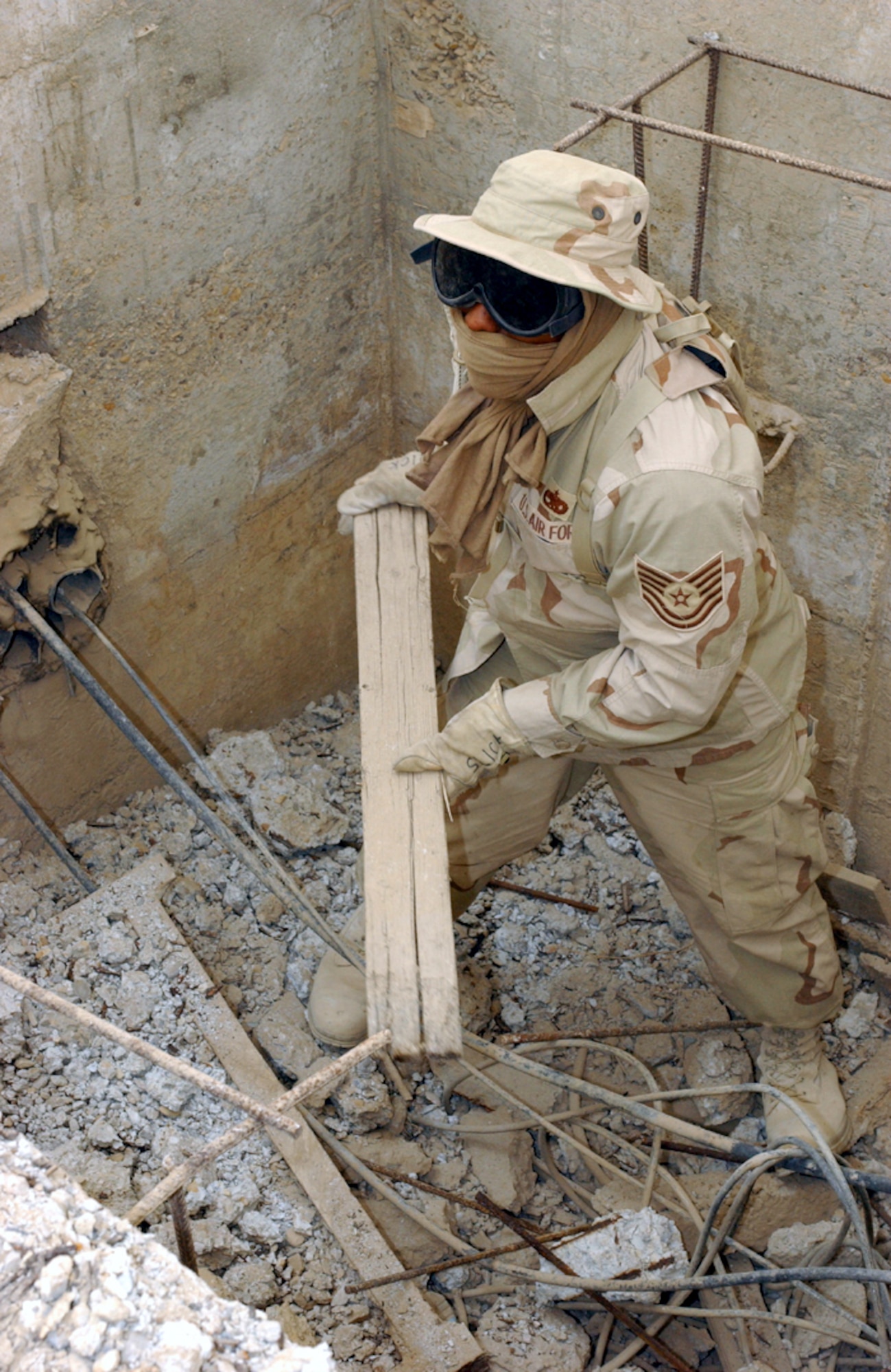 OPERATION IRAQI FREEDOM -- Tech. Sgt. Denny Tankslery clears debris from a collapsed manhole to make way for fiber-optic cable at Tallil Air Base in southern Iraq.  He is assigned to the 5th Combat Communications Group from Robins Air Force Base, Ga.  (U.S. Air Force photo by Master Sgt. Terry L. Blevins)