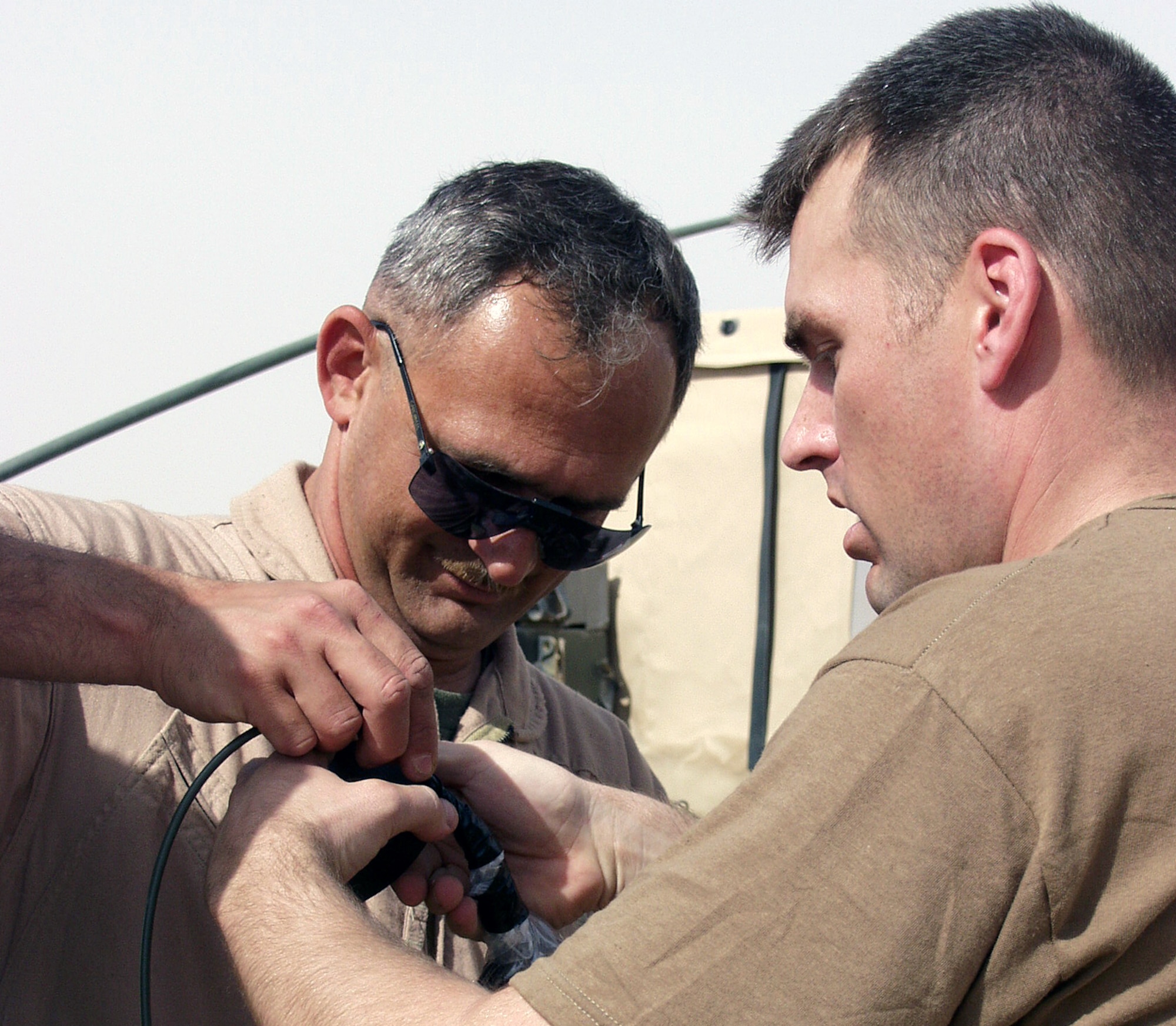 OPERATION IRAQI FREEDOM -- Marine Corps Master Sgt. Roy Dickison (left) and Staff Sgt. Edward Lockhart and prepare a smokeless powder bag to burn rocket propellant.  Both men are explosive ordnance disposal technicians at a forward-deployed location.  (U.S. Air Force photo by Staff Sgt. Karen J. Tomasik)