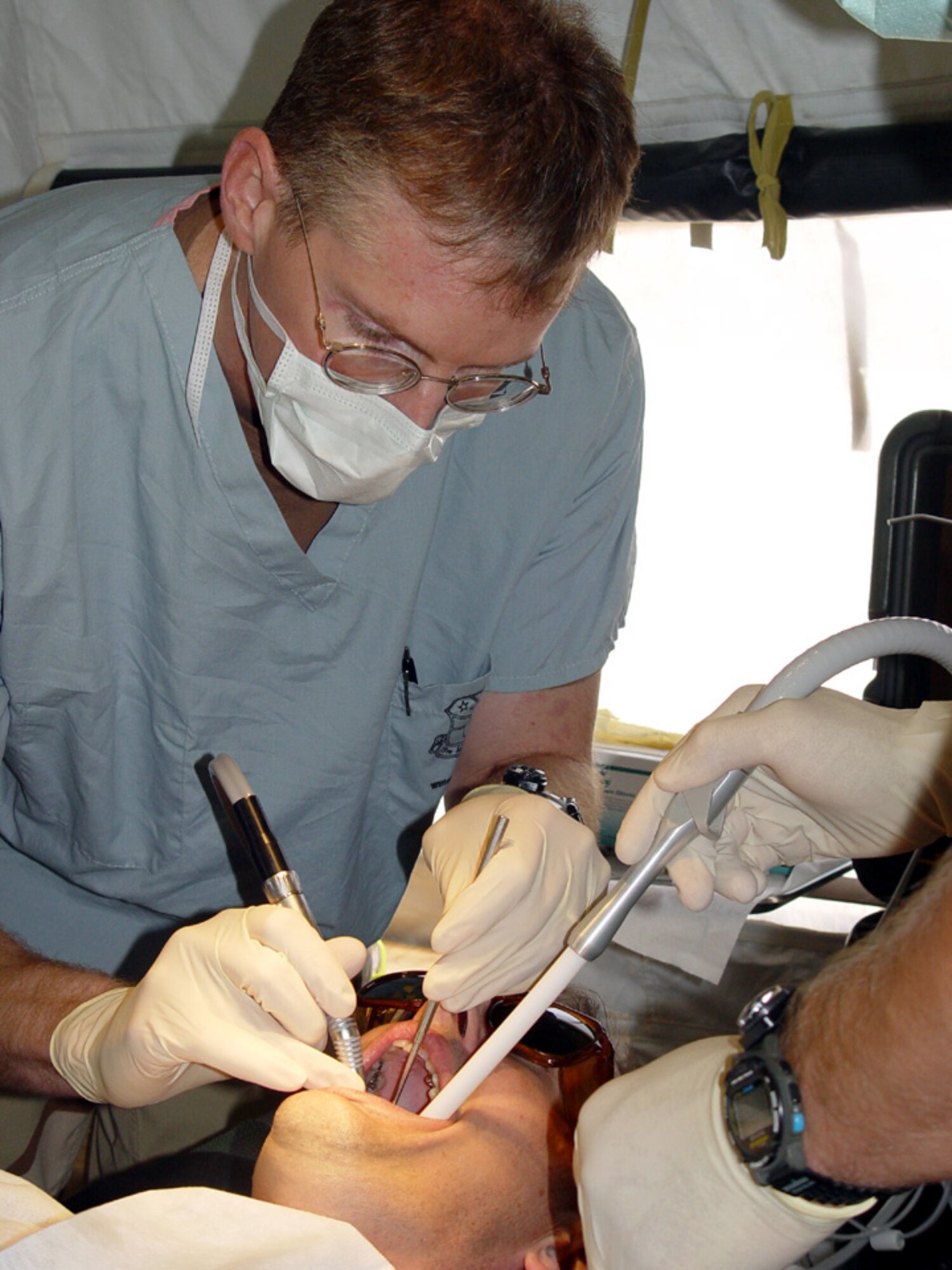 OPERATION IRAQI FREEDOM -- Lt. Col. (Dr.) Alan Sutton treats a patient at the newly opened dental clinic at a forward-deployed location.  Sutton is the sole member of the dental flight serving the 380th Air Expeditionary Wing.  He is deployed from Lackland Air Force Base, Texas.  (U.S. Air Force photo by 2nd Lt. Nancy Kuck)